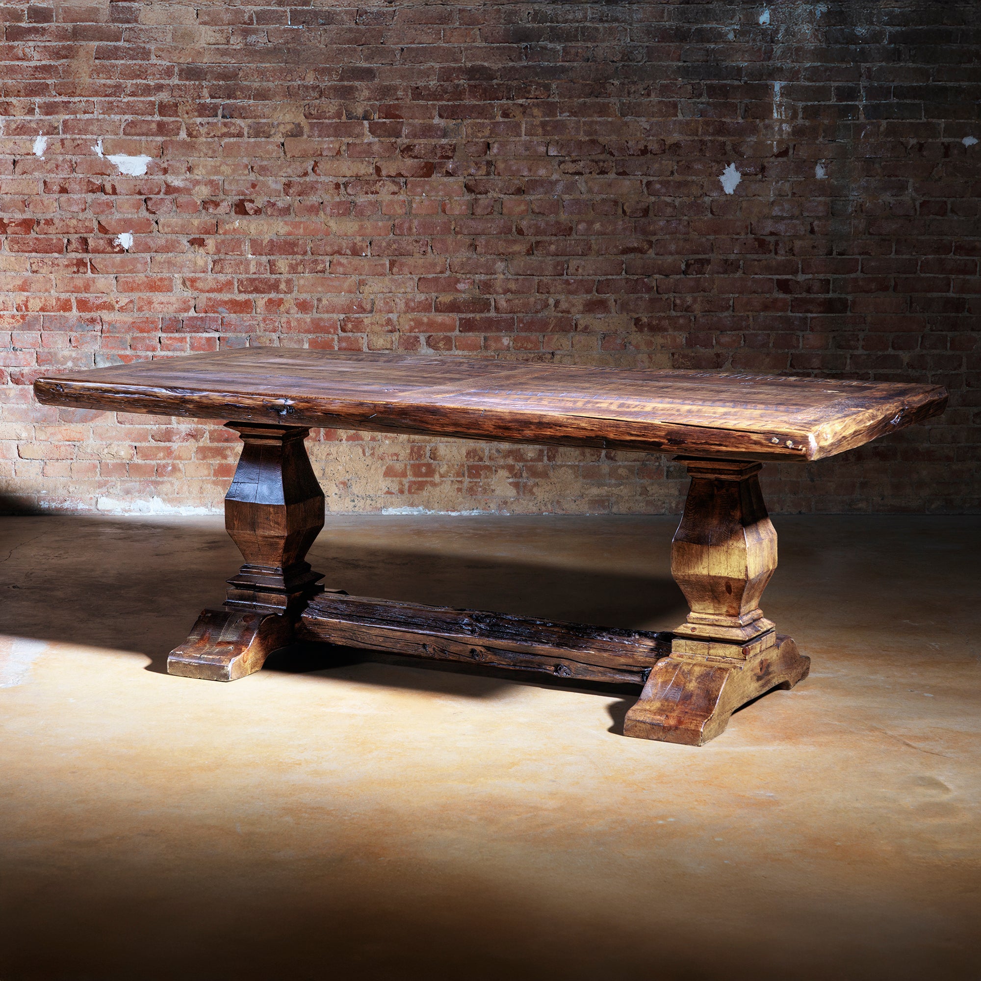Luxury Western dining table handcrafted from reclaimed wood with double pedestal base and distressed finish.