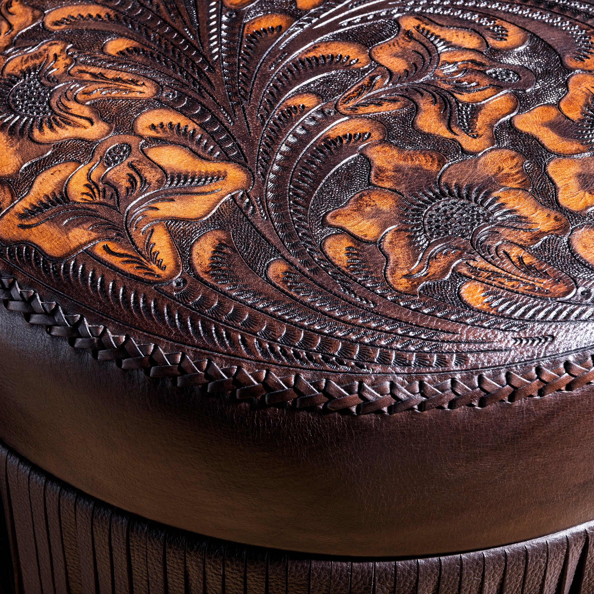 Detailed floral saddle-tooling pattern on round top-grain leather ottoman