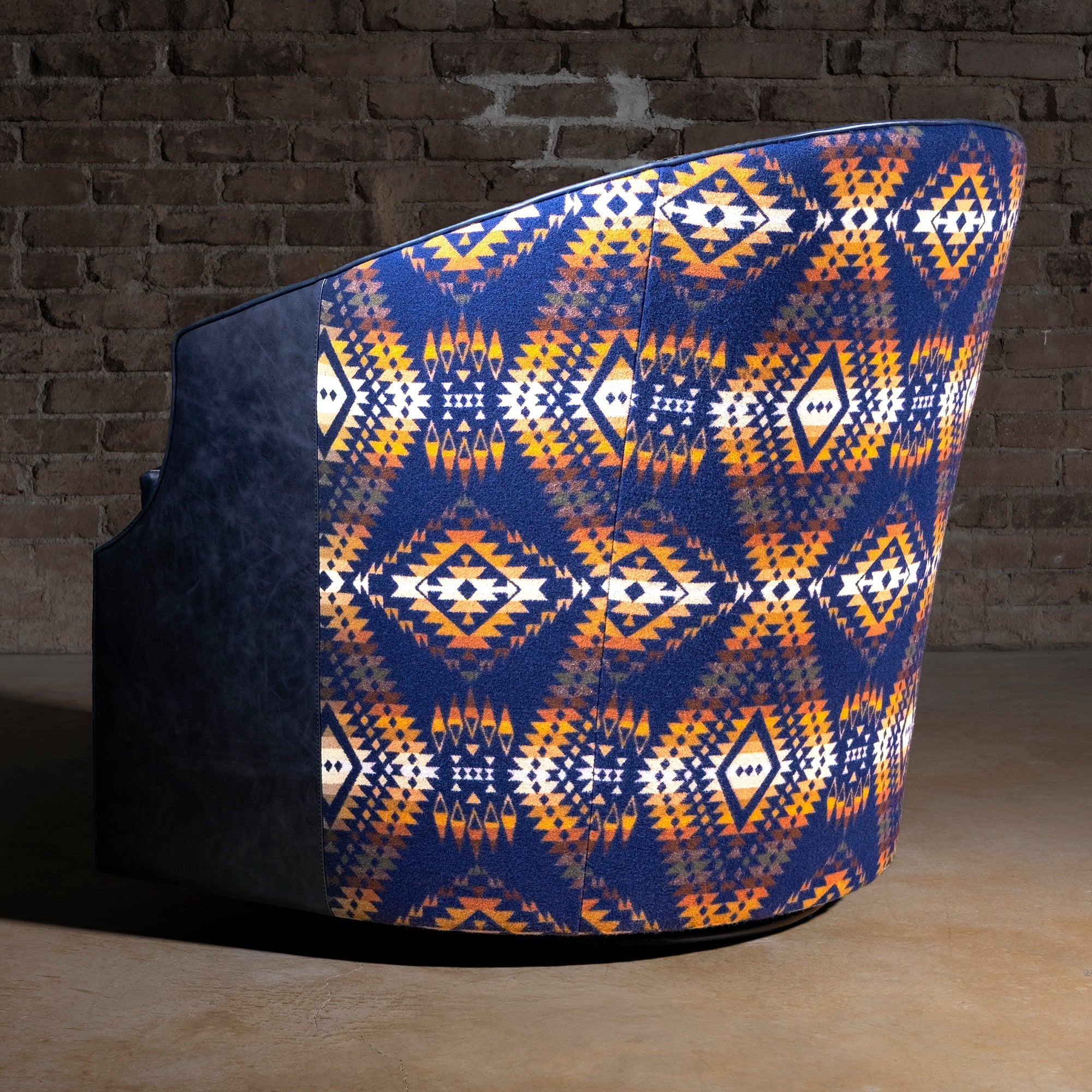 Midnight Caballero western swivel chair rear view with Pendleton textile, blue leather sides, curved back, and 360-degree base