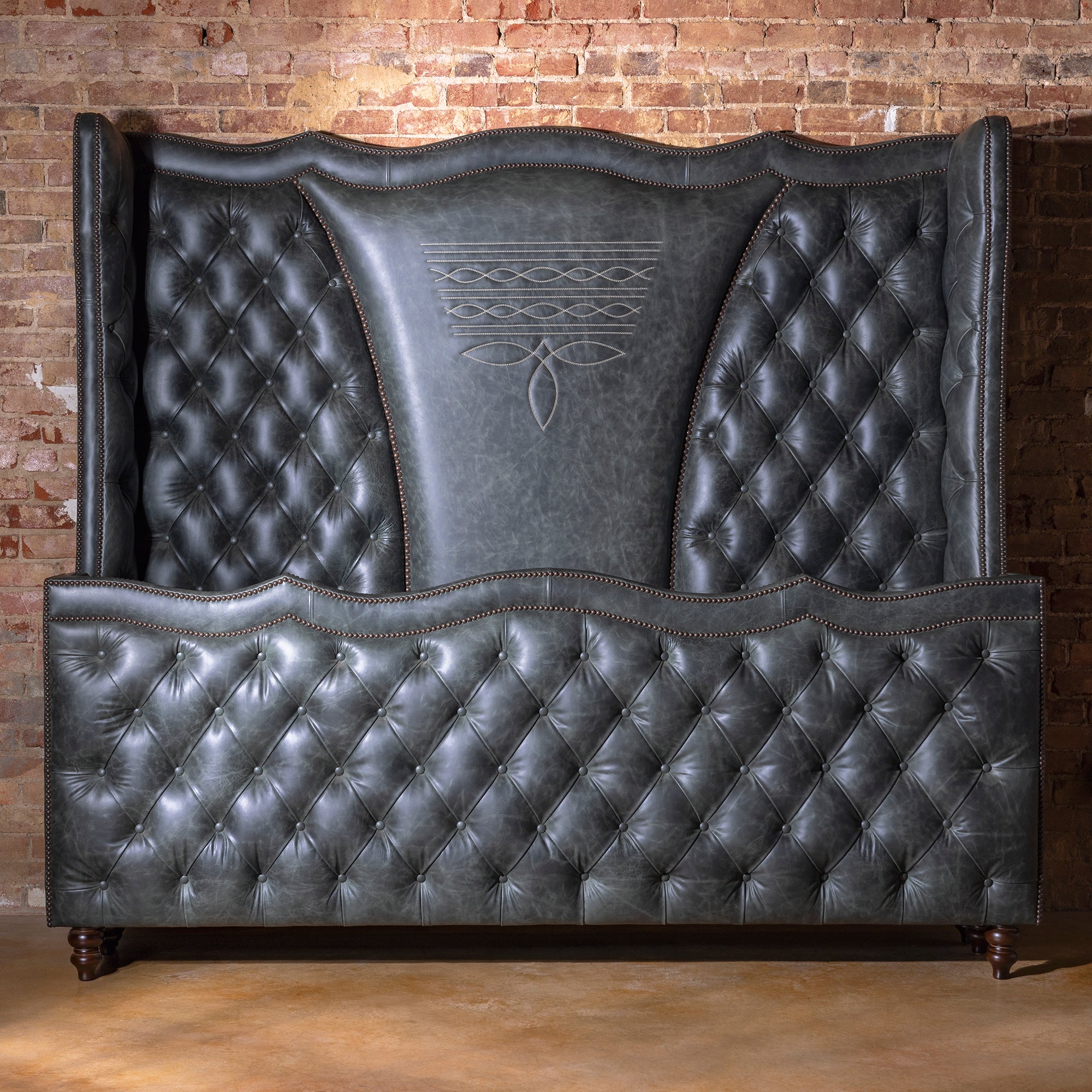 The Navarro Bootstitch Bed in storm-gray top-grain leather with tufted headboard – Into The West