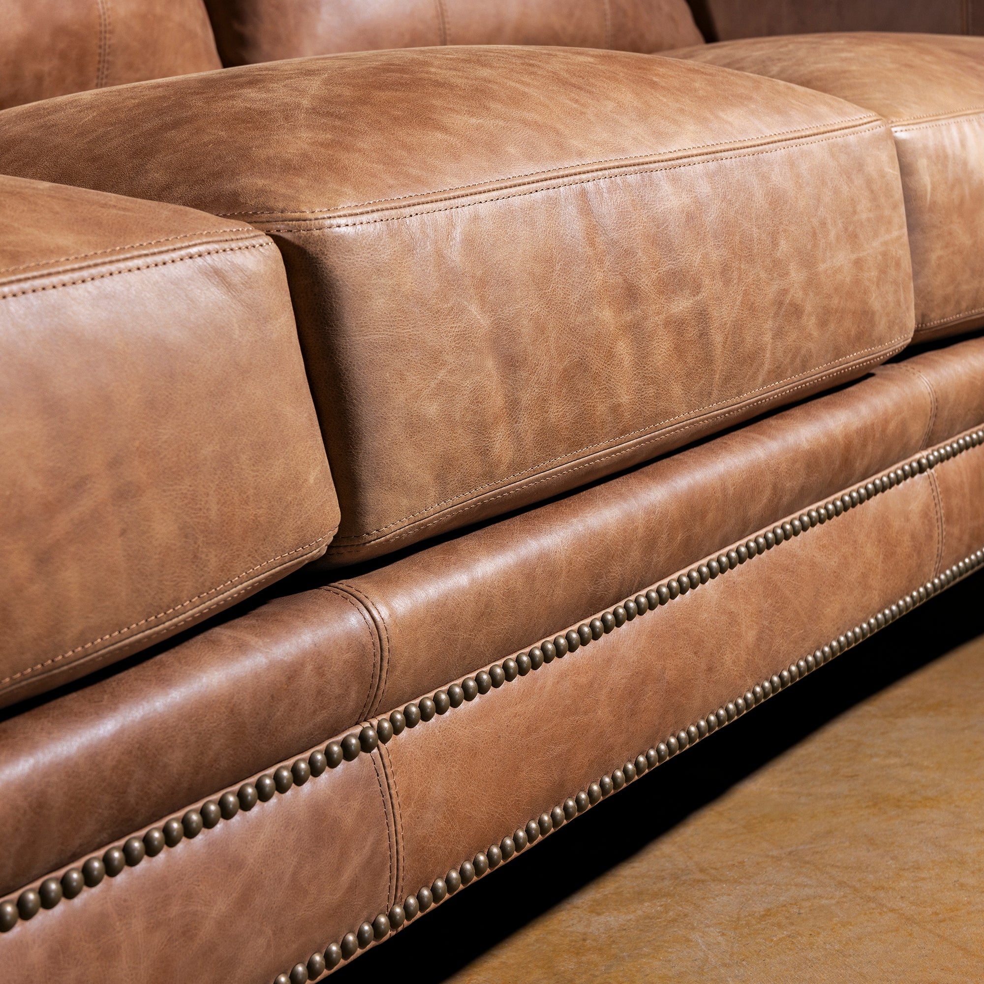 Front rail and nailhead trim closeup on Oakley Frontier top grain leather Western sofa