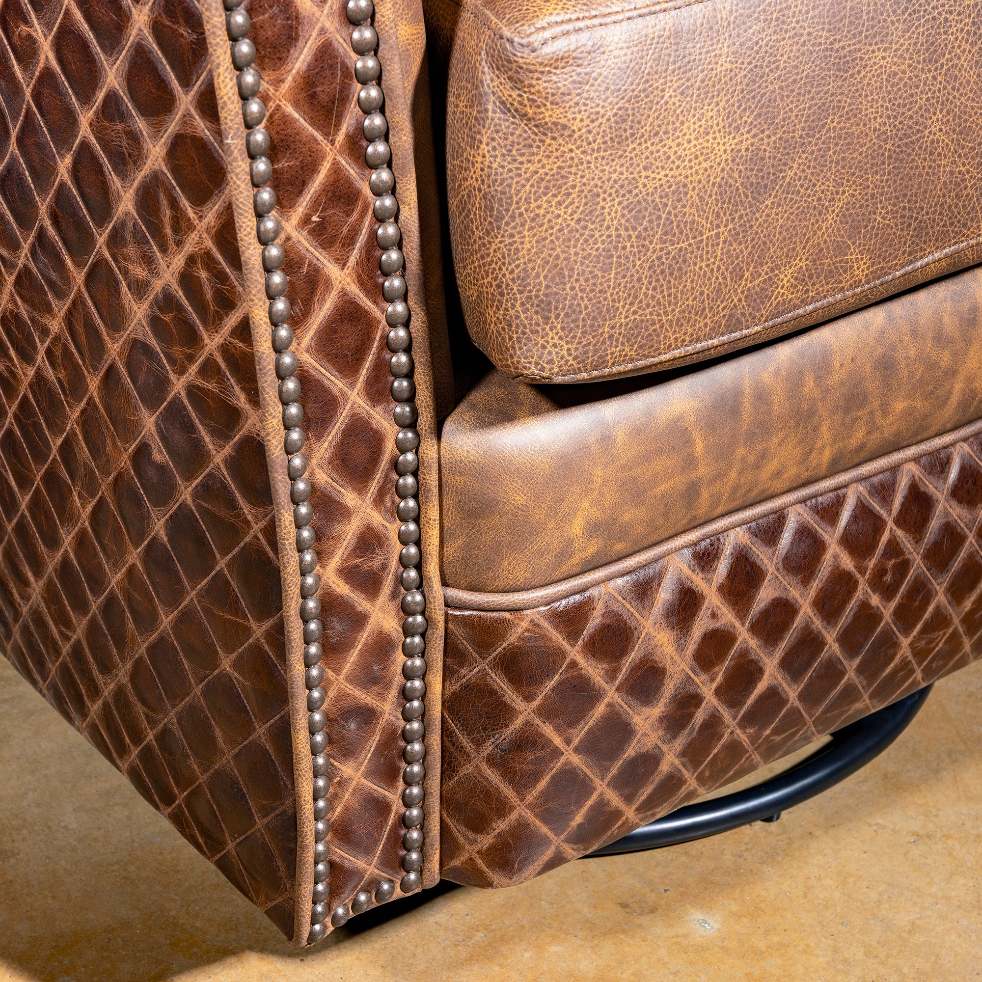 Palacio Bronce Western Leather Swivel Chair close-up with distressed leather, diamond-embossed panels, nailheads, and swivel base.