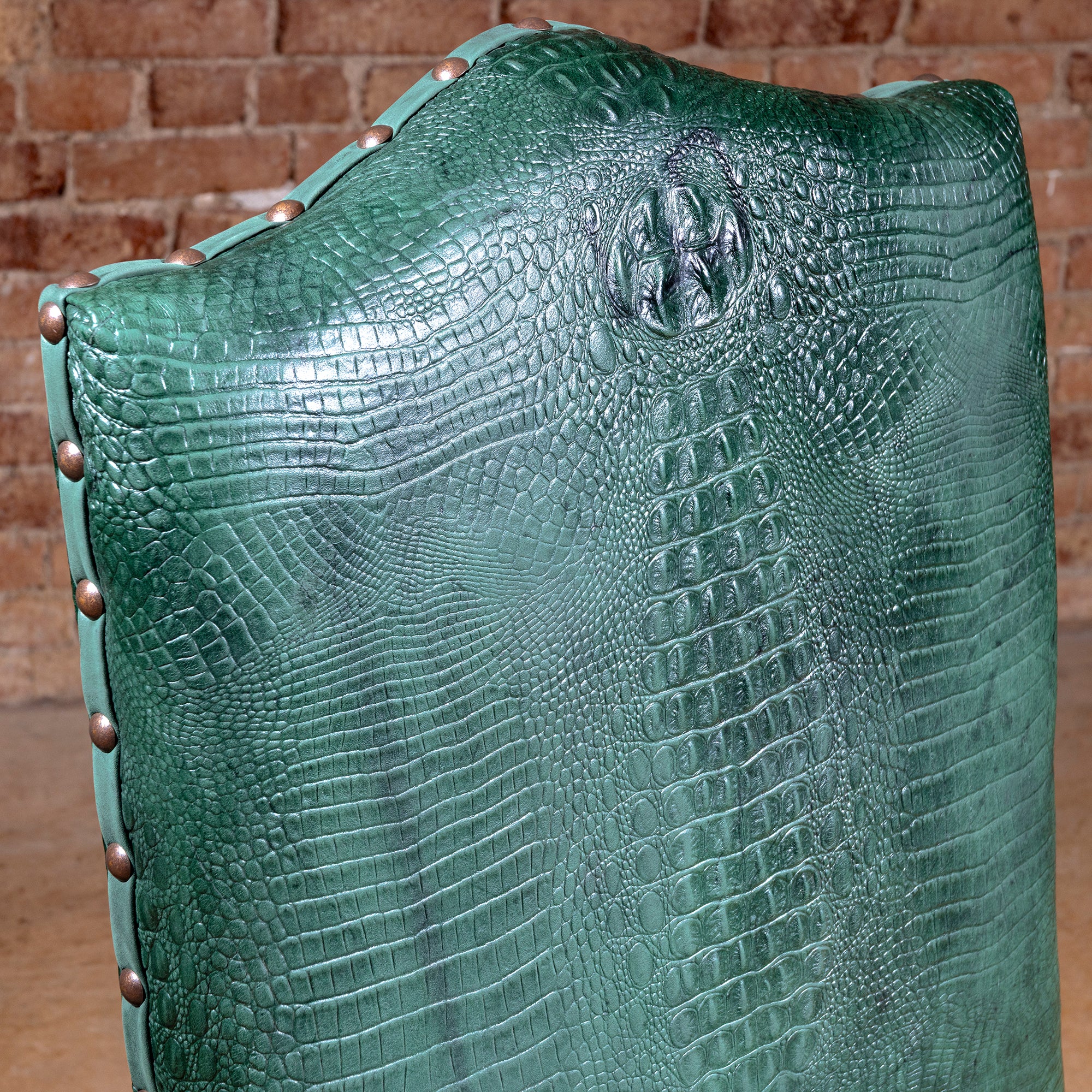 Palacio Verde Dining Chair closeup of green croc-embossed leather backrest with sculpted texture and nailhead trim