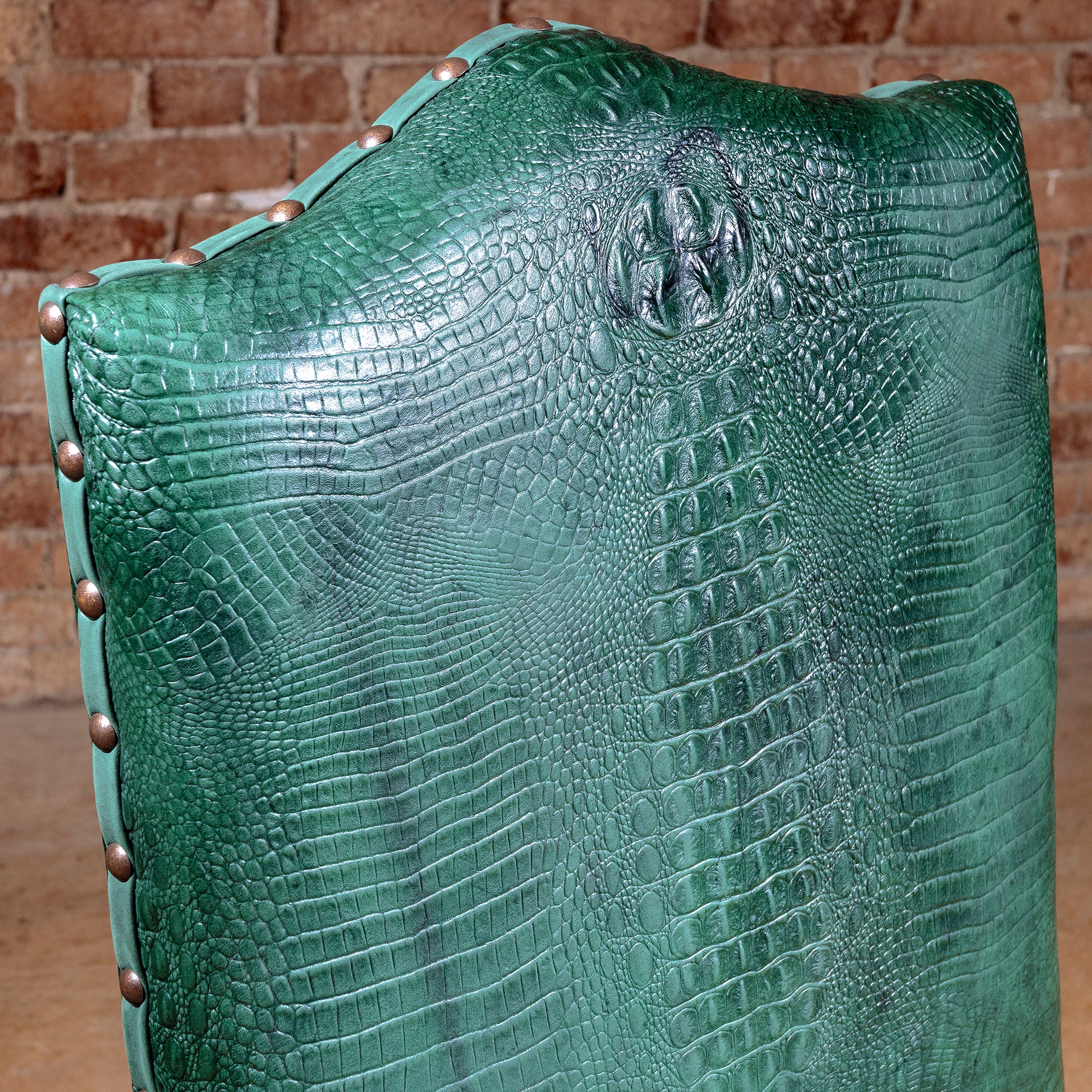 Palacio Verde Dining Chair closeup of green croc-embossed leather backrest with sculpted texture and nailhead trim
