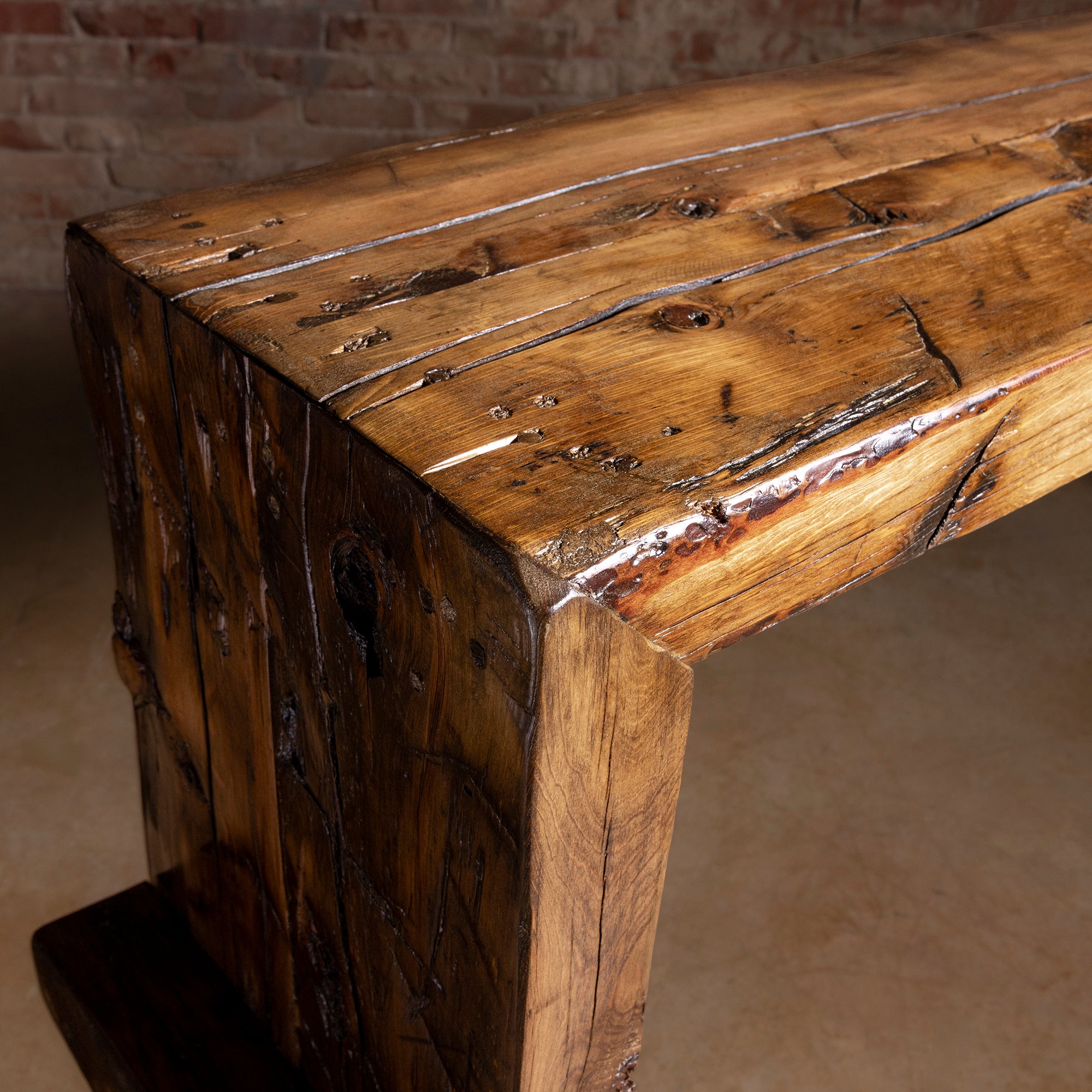 Corner closeup of reclaimed beam console top with aged wood markings