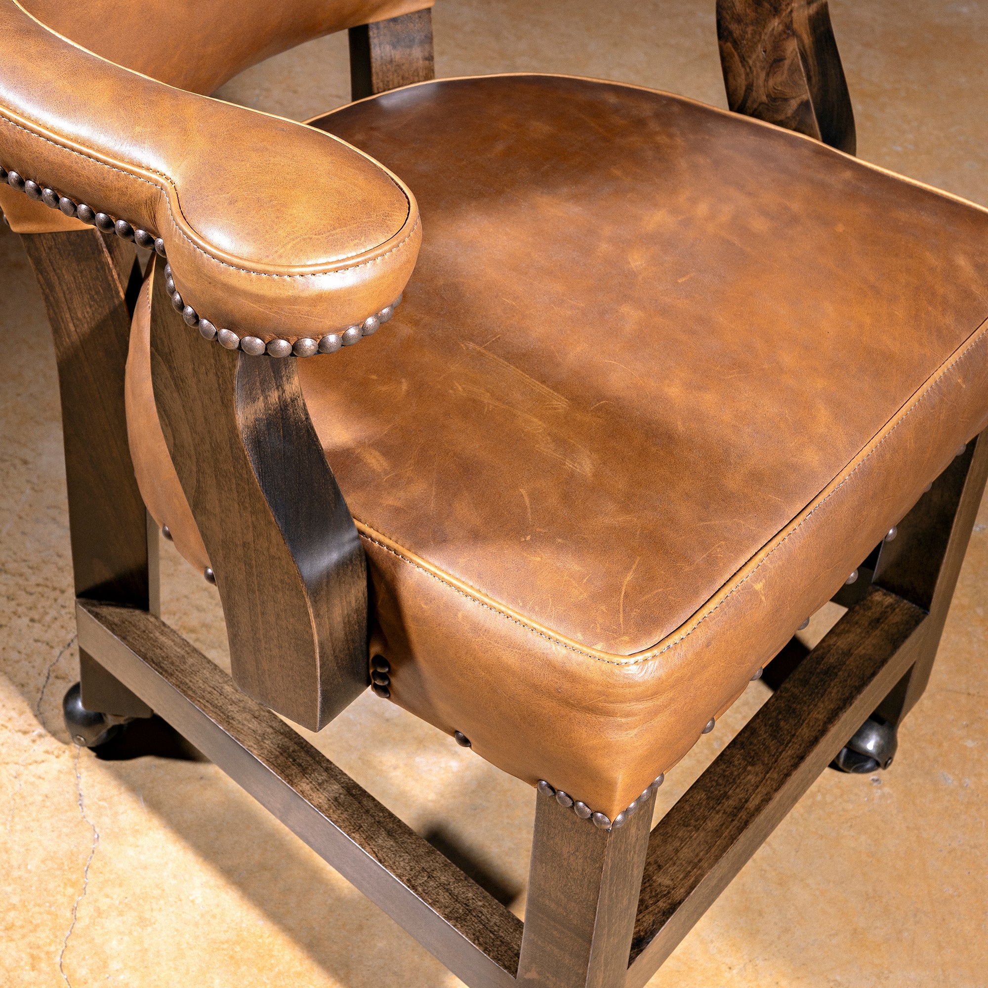 Presidio Dealer Chair black yoke back detail on a Western poker chair with tan leather, nailheads, and alder wood base