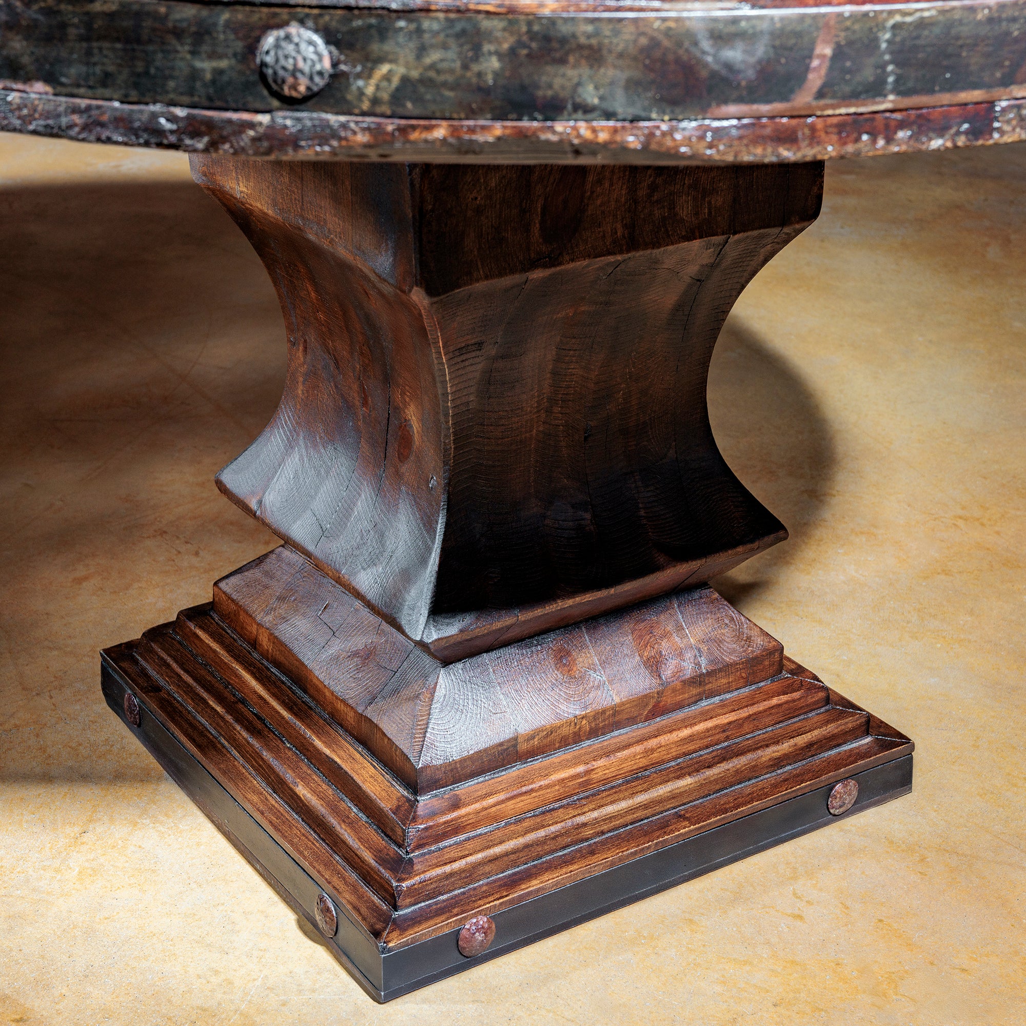 Sculpted pedestal base in rich wood tones with stepped molding