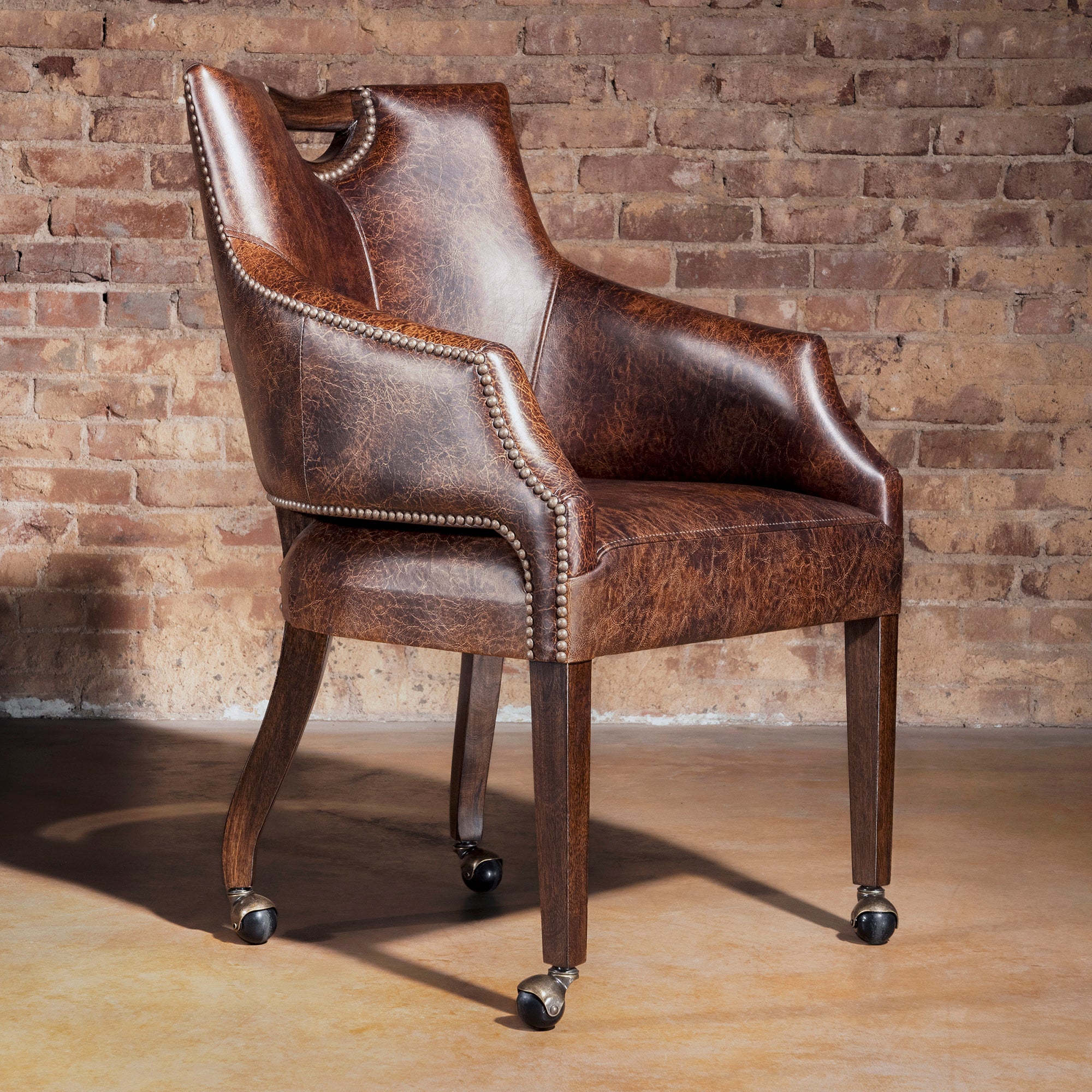 Riverstone Nailhead Game Chair in distressed top-grain leather with casters