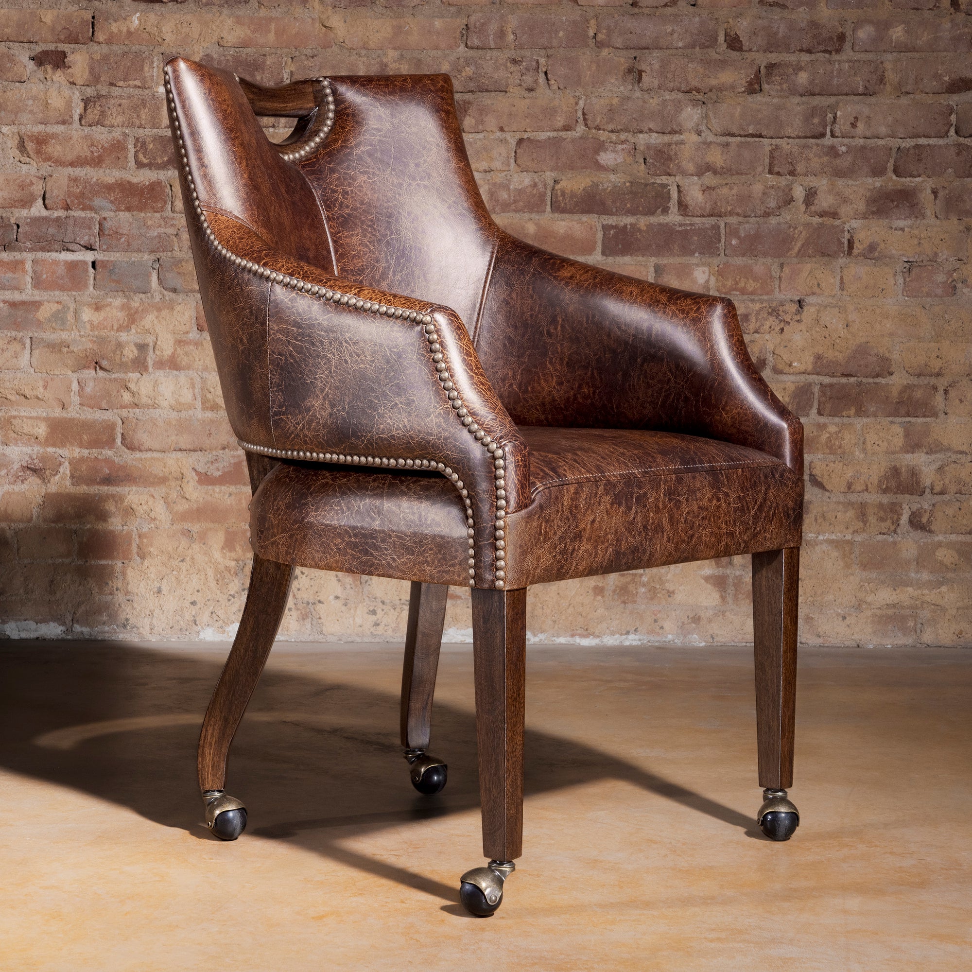 Riverstone Nailhead Game Chair in distressed top-grain leather with casters
