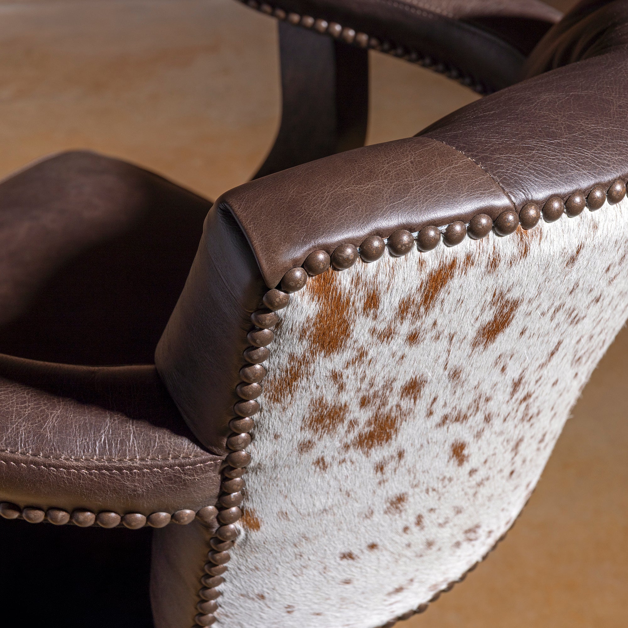 Sable Crest Hideback Bar Stool western cowhide bar stool hide detail with natural brown and white hair-on-hide back panel and nailheads.
