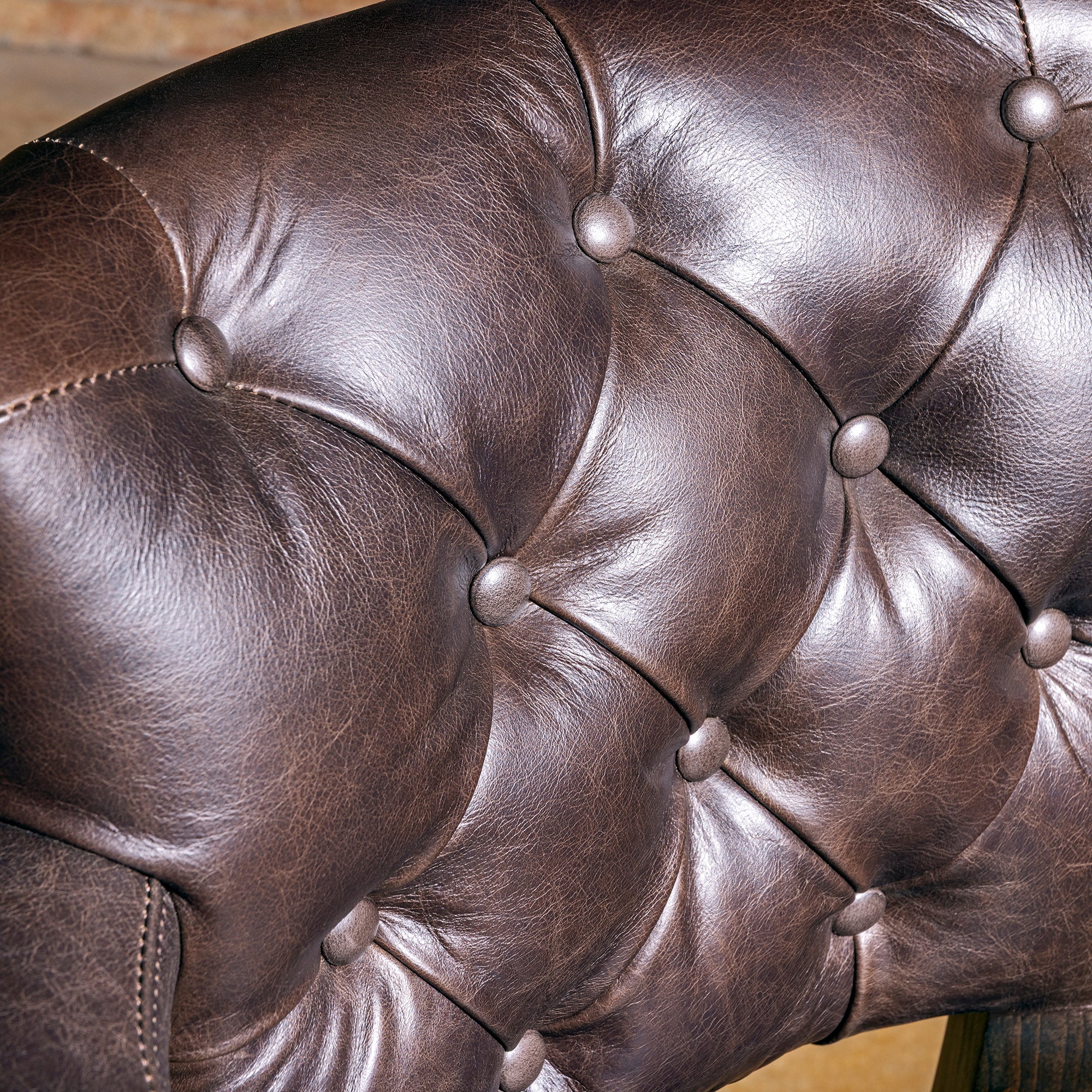 Sable Crest Hideback Bar Stool western cowhide bar stool tufted back detail with rich brown top-grain leather and tailored buttoning.