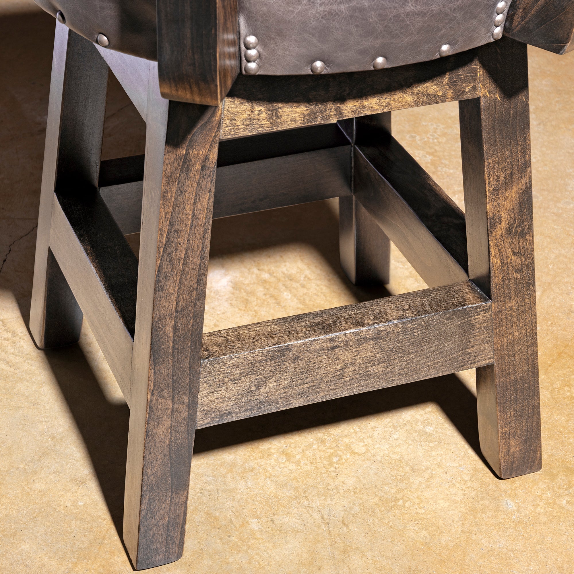 Sable Crest Hideback Bar Stool western cowhide bar stool alderwood base detail with dark finished legs and stretcher support.