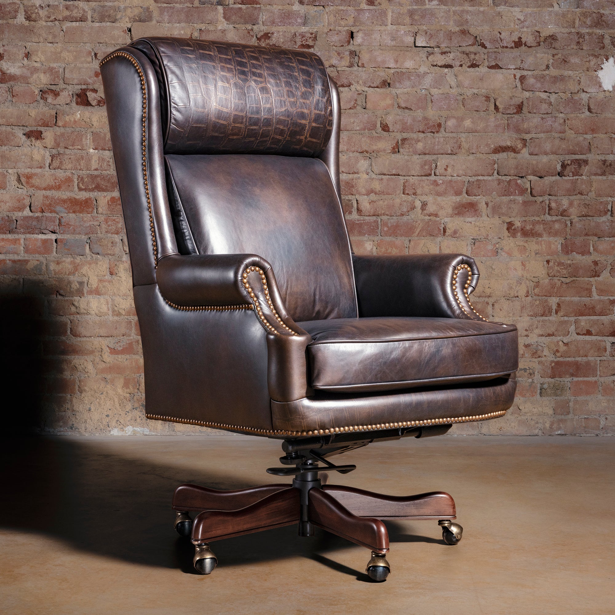 High back Western leather executive desk chair with croc-embossed headrest, antique nailheads, and wood caster base.
