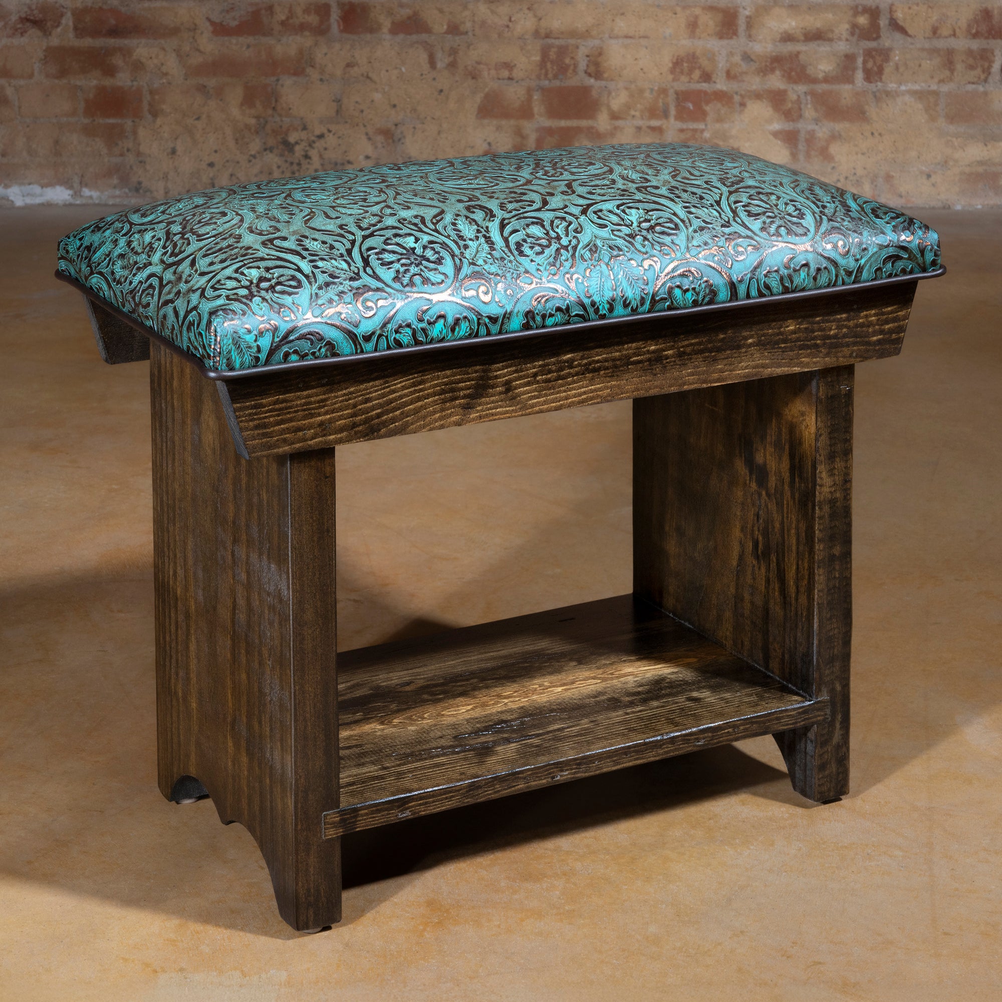 Turquoise tooled leather Western bench with dark stained wood base and lower shelf, shown in studio setting