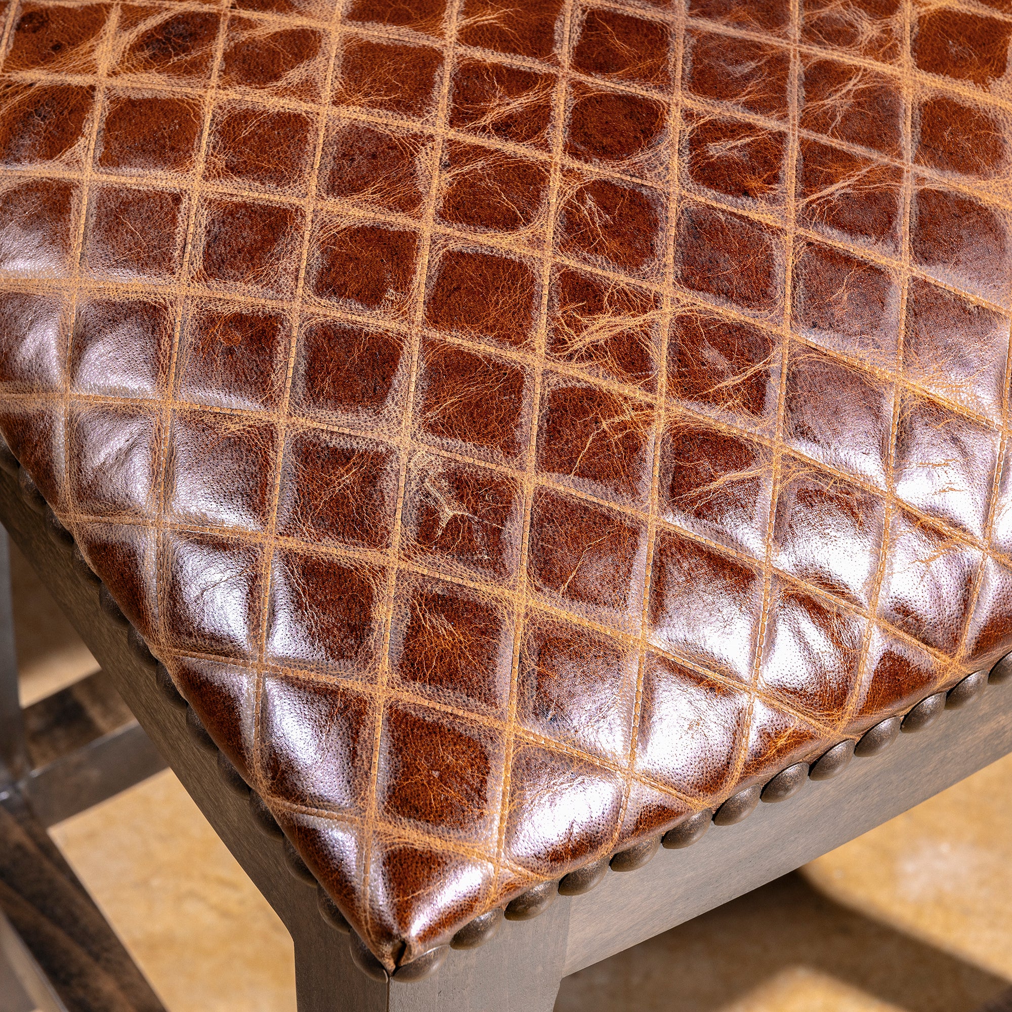 Tascosa Saddle Stool close detail of croc-embossed top-grain leather seat with rich saddle-brown Western texture