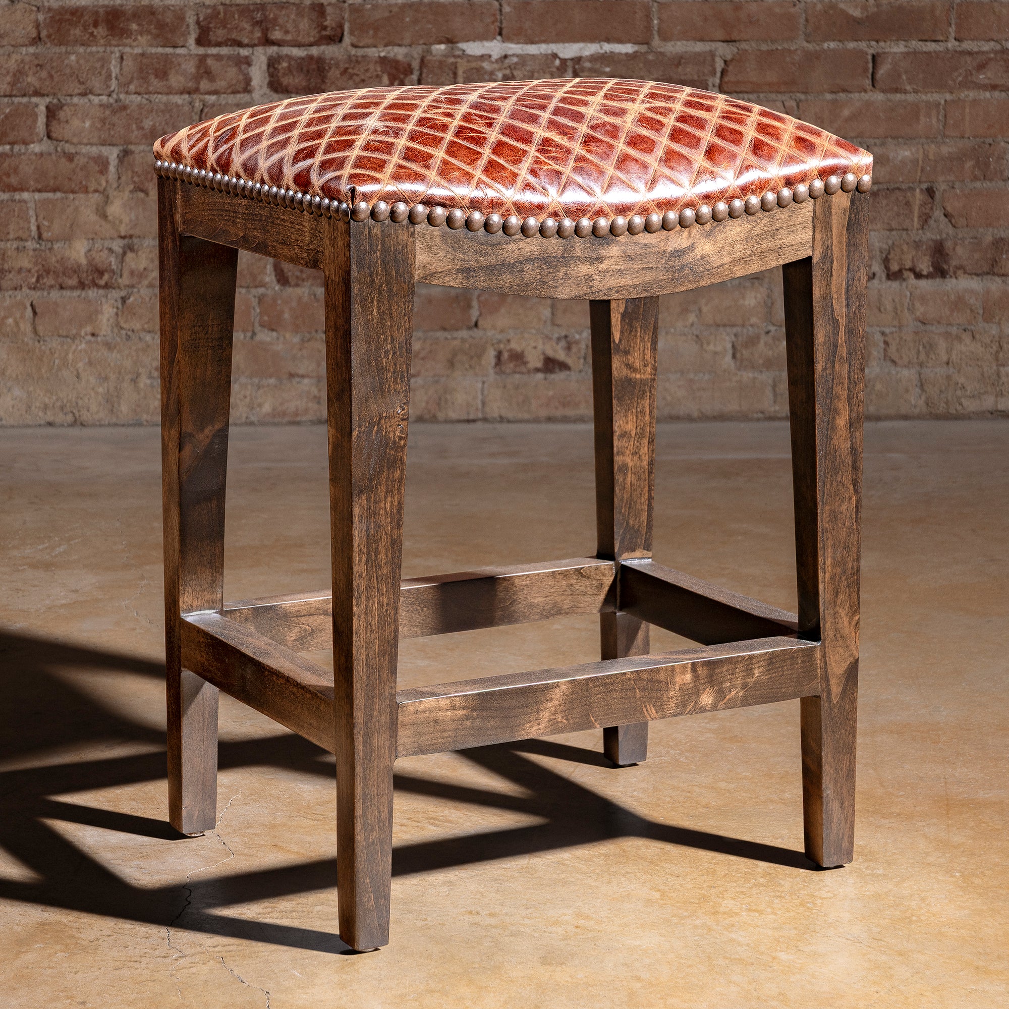 Tascosa Saddle Stool rustic Western saddle stool with antique nailhead border, padded leather seat, and alder base