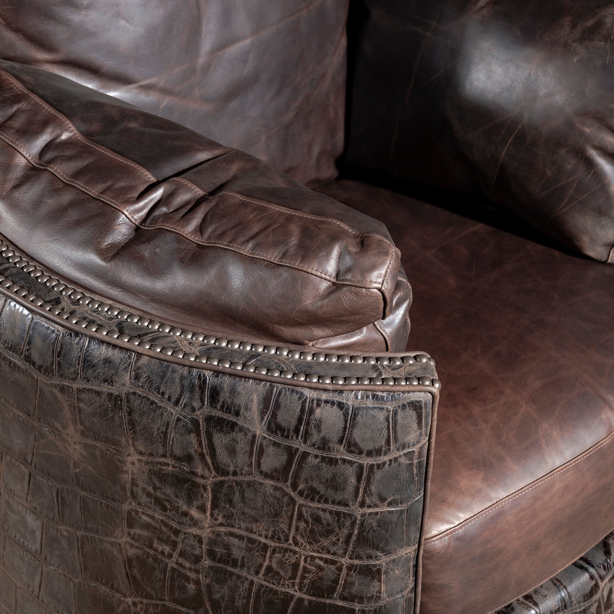 Nailhead trim detail framing croc hide and leather armrest – Into The West