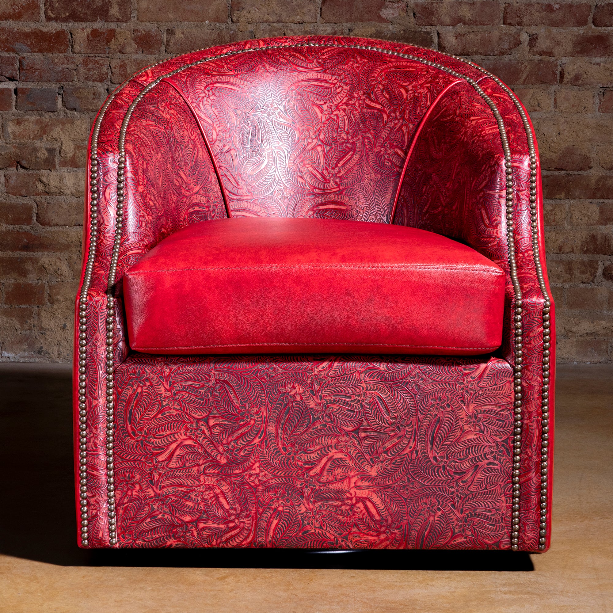 Front view of Vaquera Royale red leather swivel chair with tooled panels and loose seat cushion