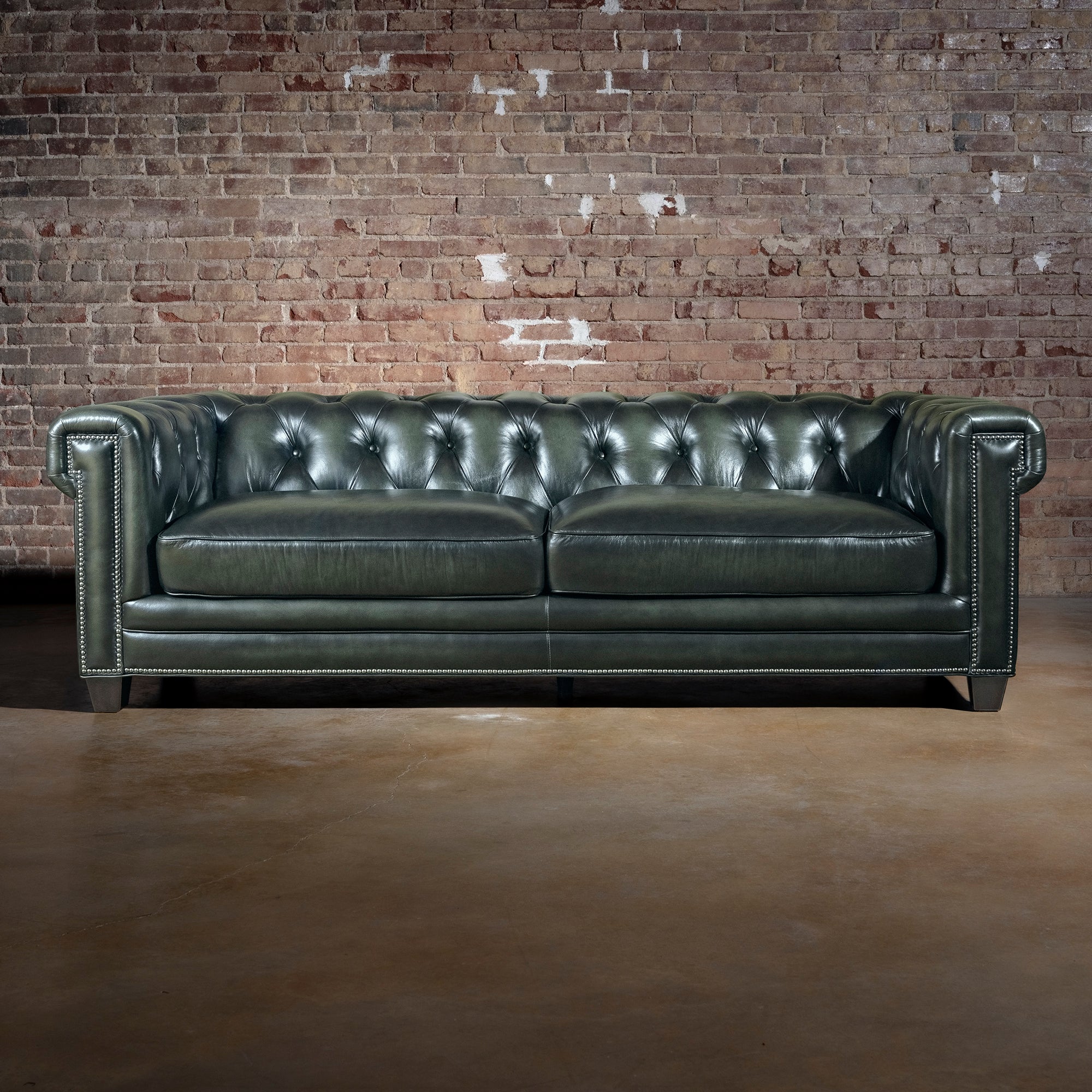 Verde Sovereign western sofa front view with button-tufted back, rolled arms, two leather cushions, and nailhead detailing