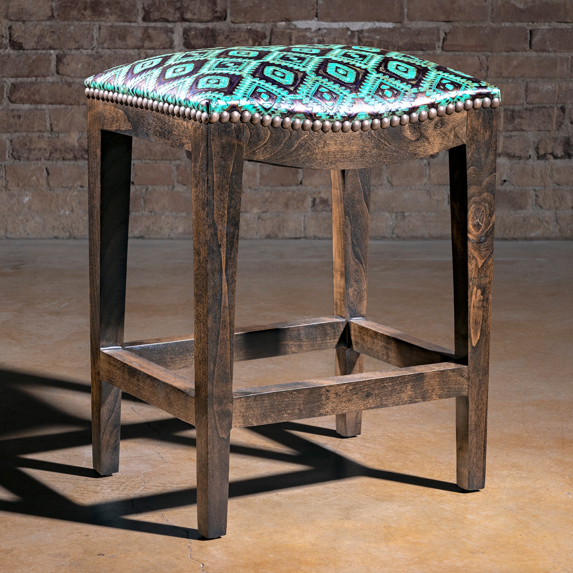 Verdigris Saddle Stool western bar stool with turquoise tooled leather seat, bronze nailhead trim, and alder wood base