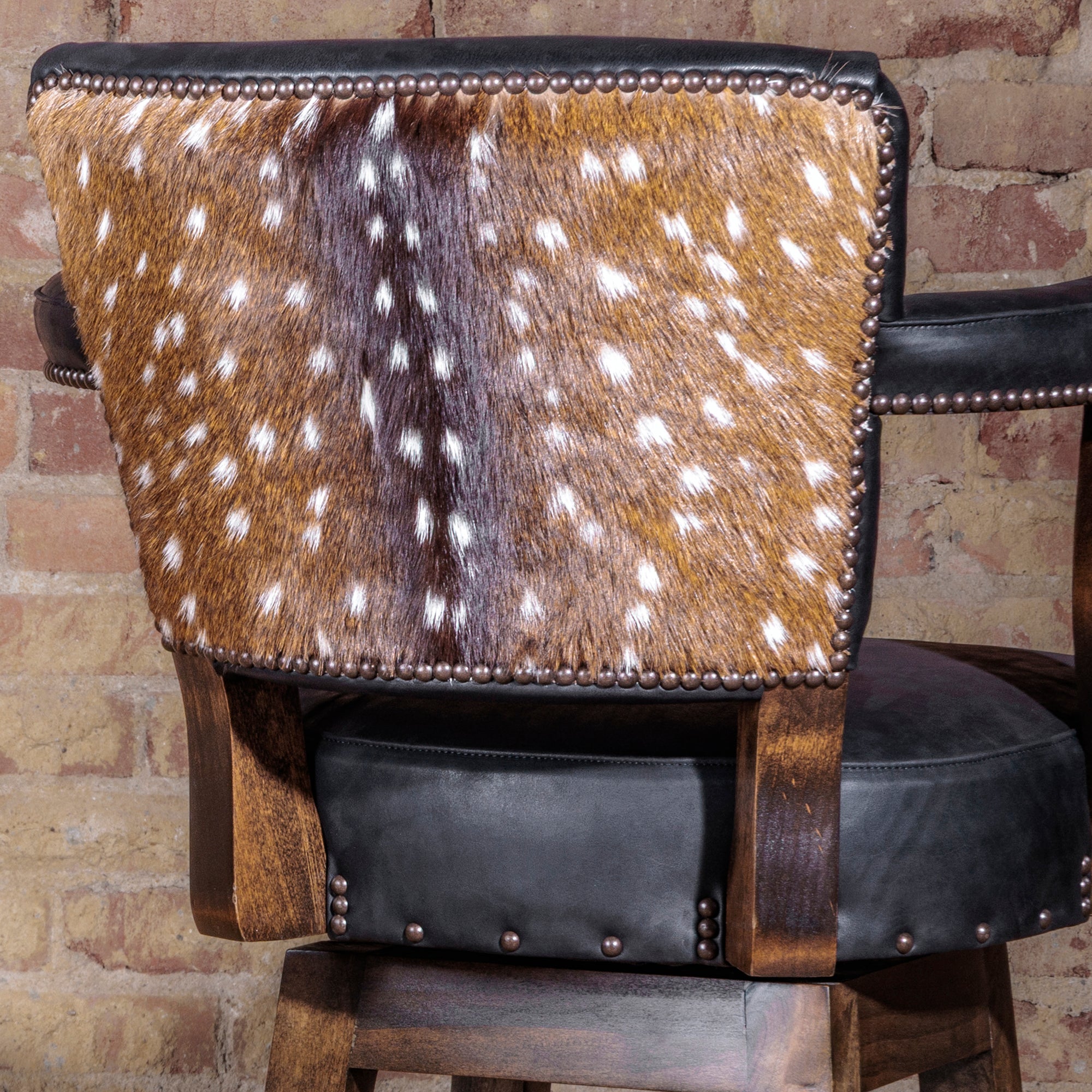 Back of bar stool featuring authentic axis hide and nailhead trim