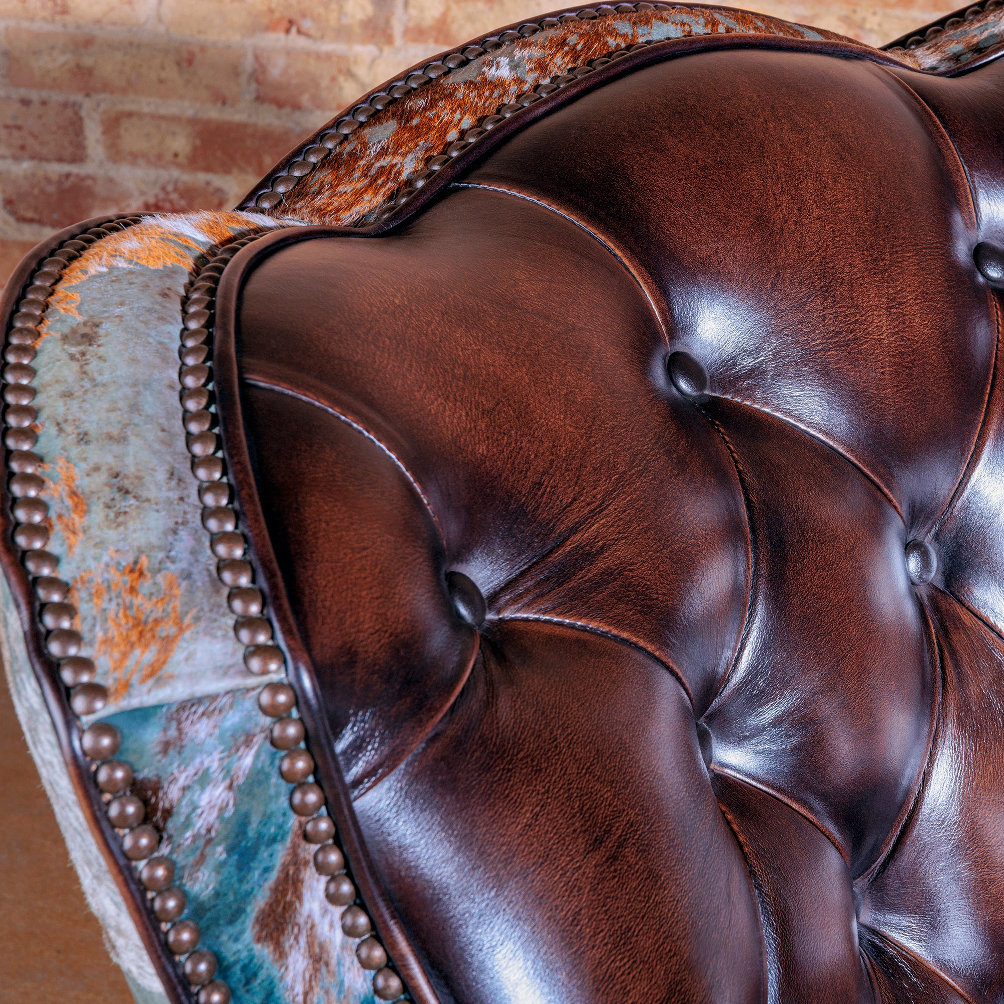 Luxury Western swivel chair with turquoise acid wash cowhide and tufted leather seat.