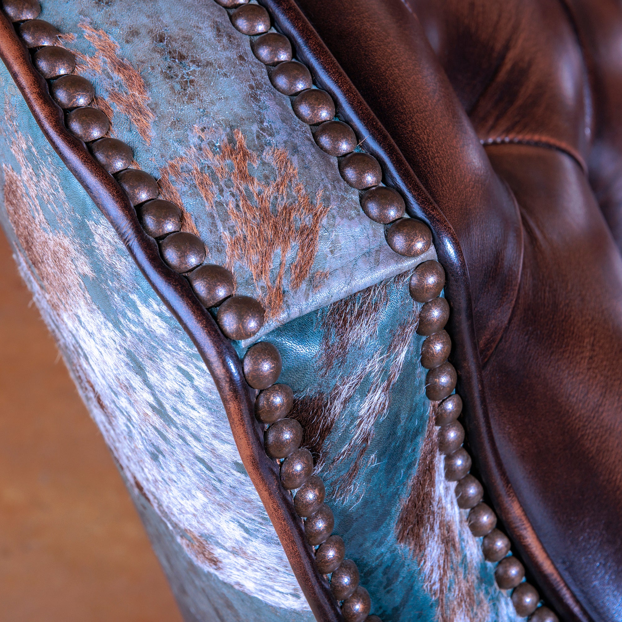 Luxury Western swivel chair with turquoise acid wash cowhide and tufted leather seat.