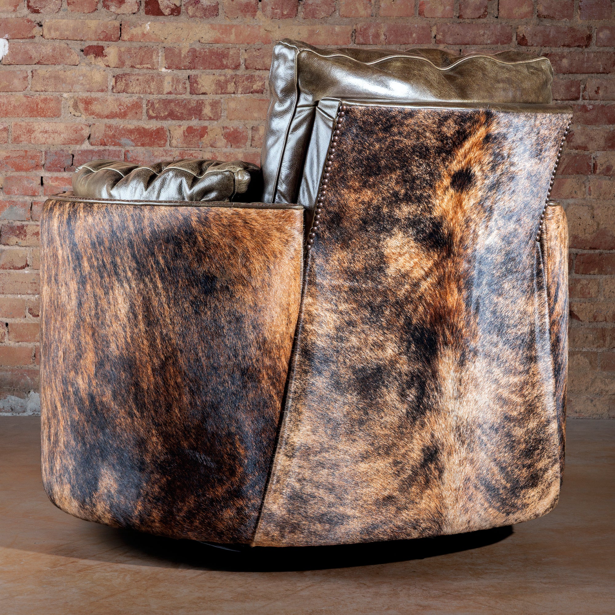 Back view of rustic cowhide and leather Western swivel recliner chair