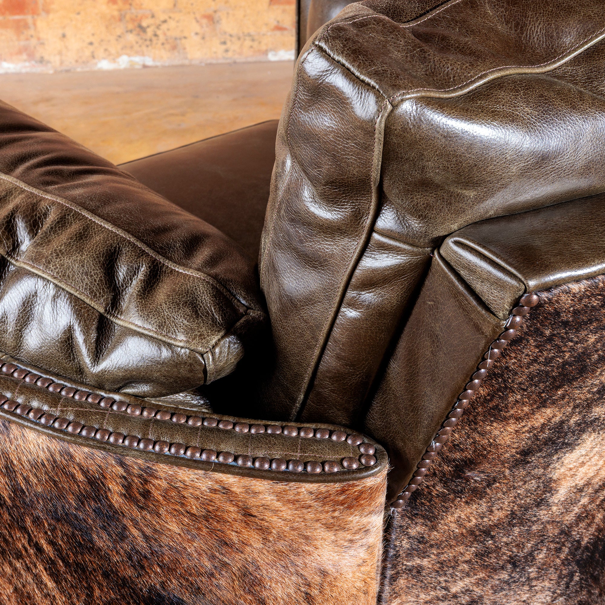 Close-up of nailhead detailing and brindle hide on handcrafted leather recliner