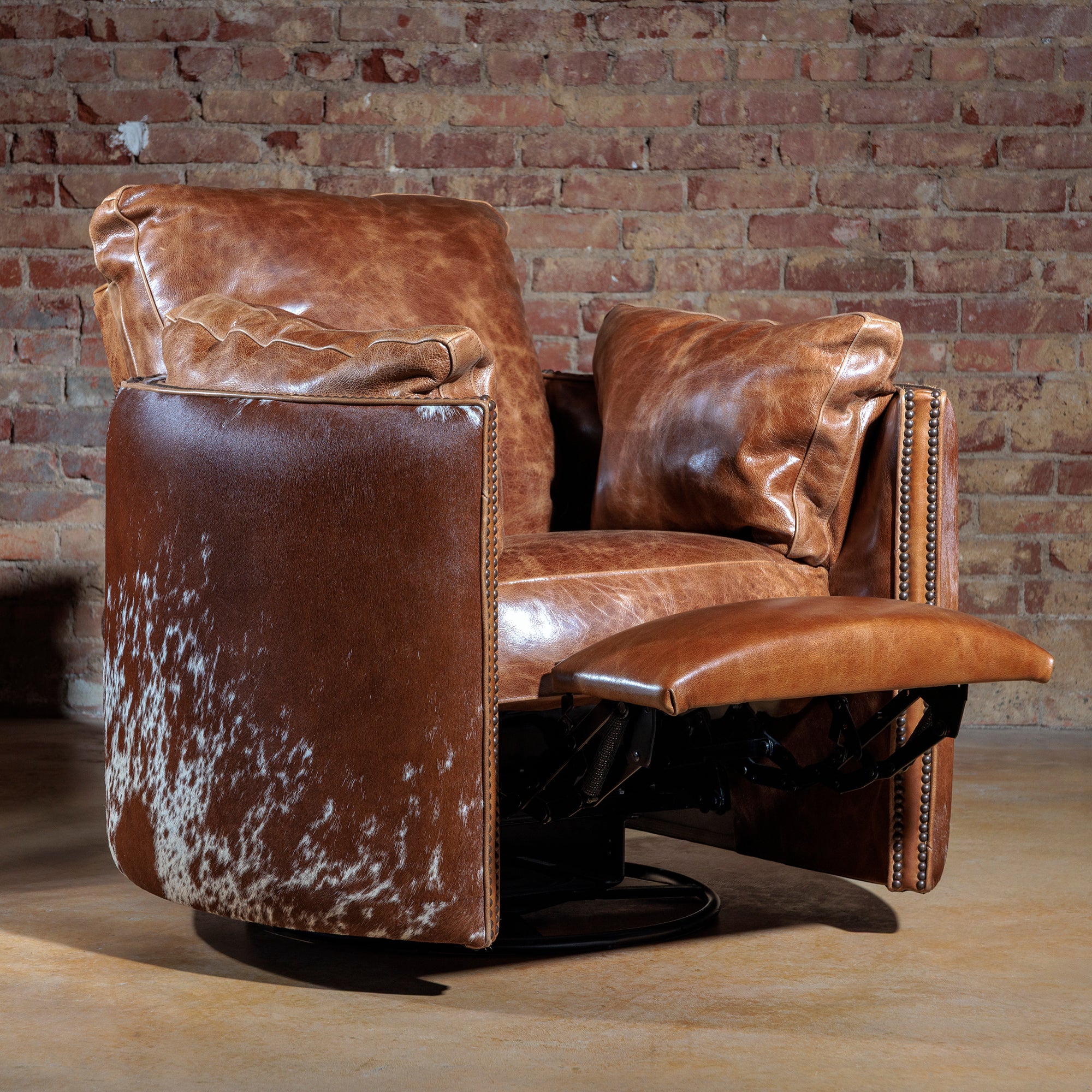 Big Texan leather recliner in push-back recline position with 360-degree swivel base and cowhide accents