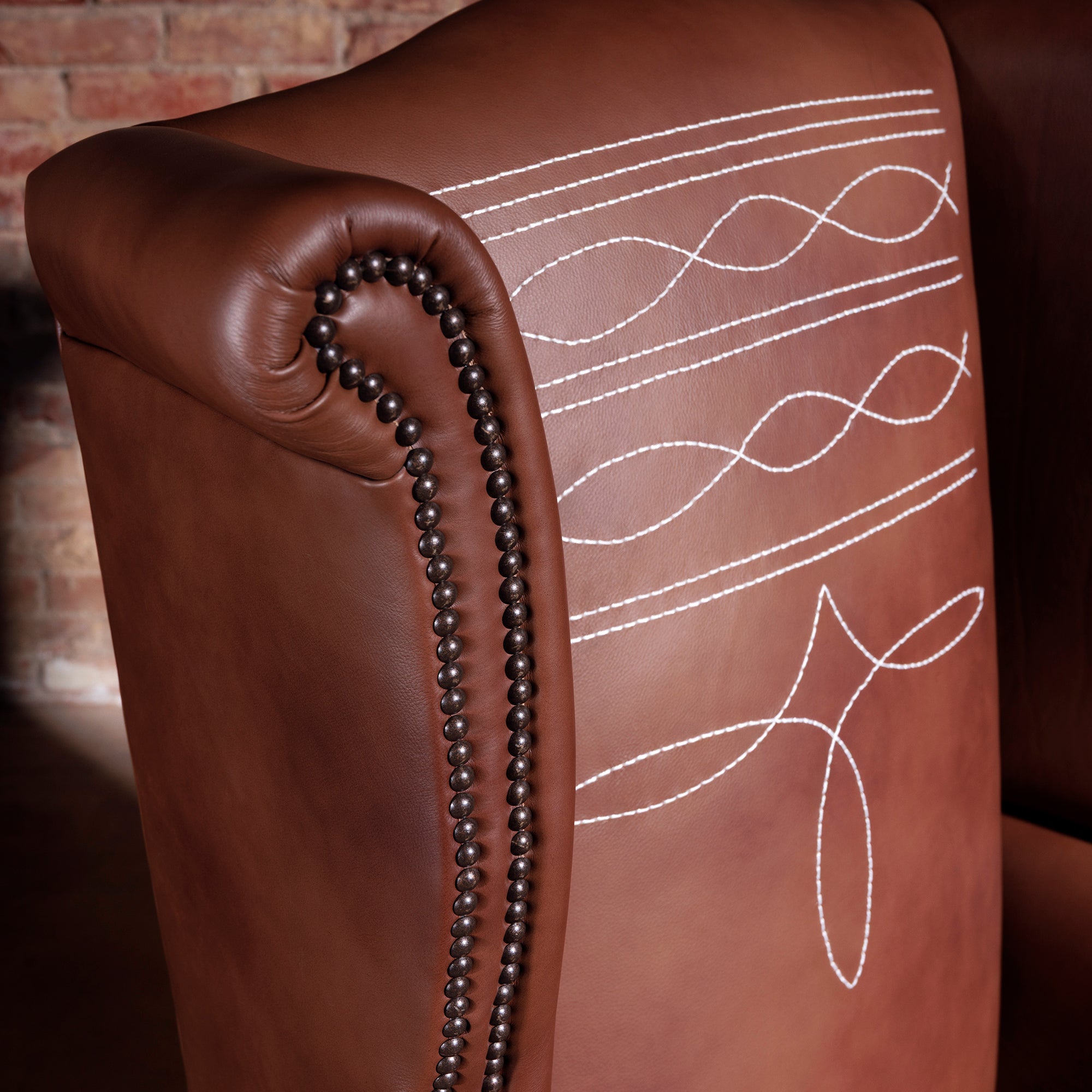 Close-up of decorative Western-style stitch pattern on leather wingback chair