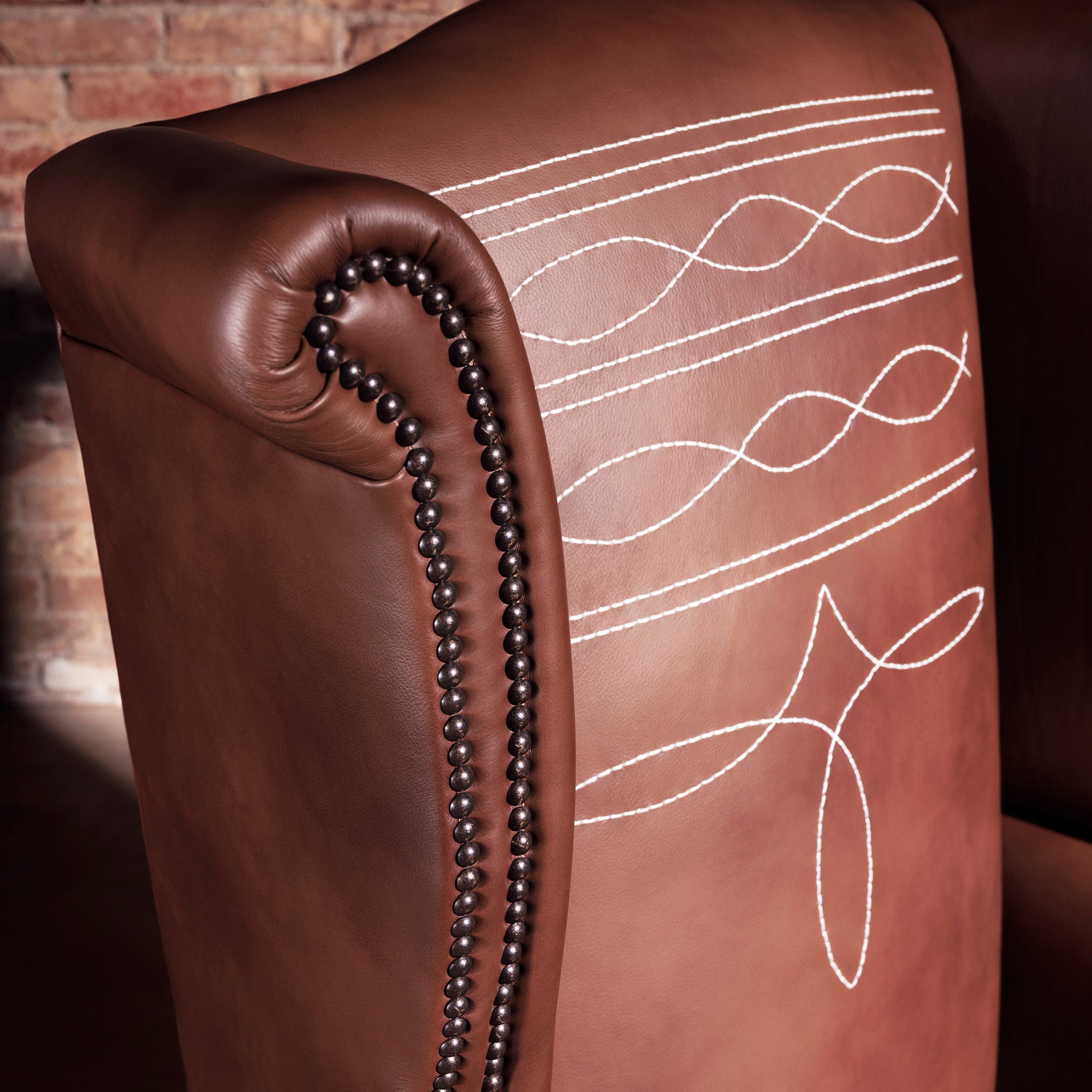 Close-up of decorative Western-style stitch pattern on leather wingback chair