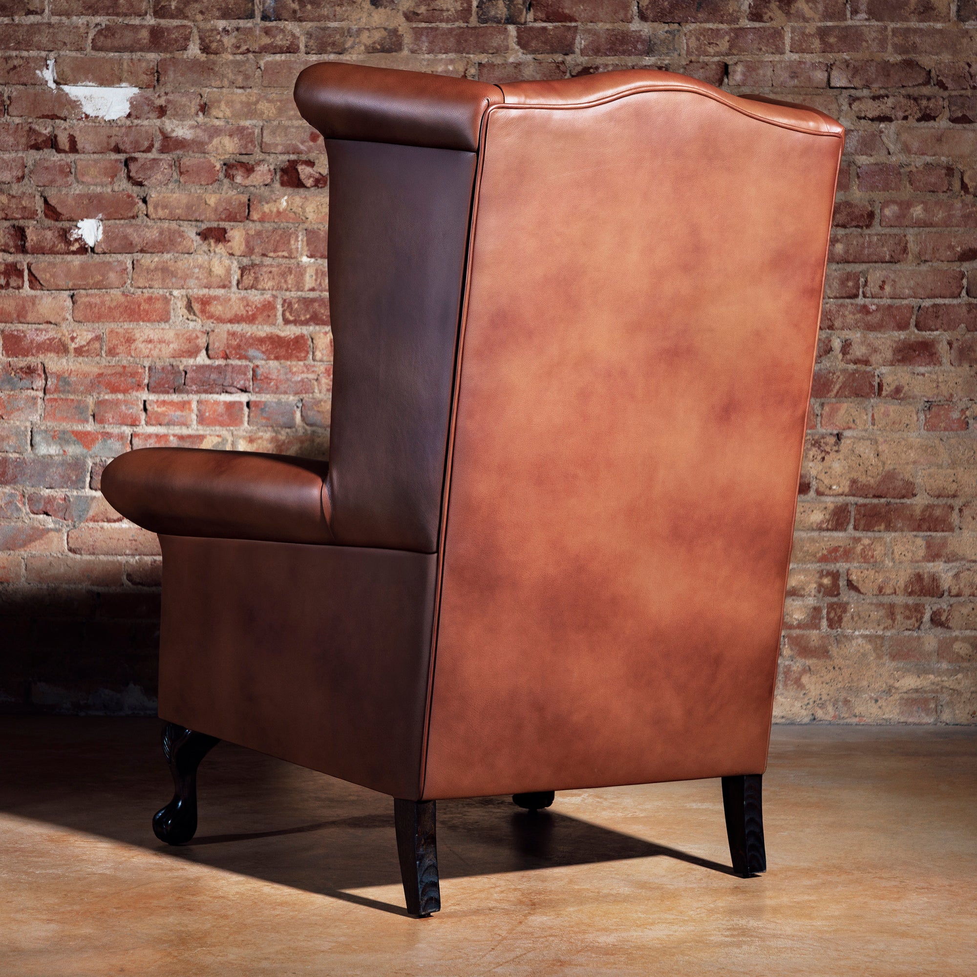 Back view of leather Western chair featuring detailed white cowboy