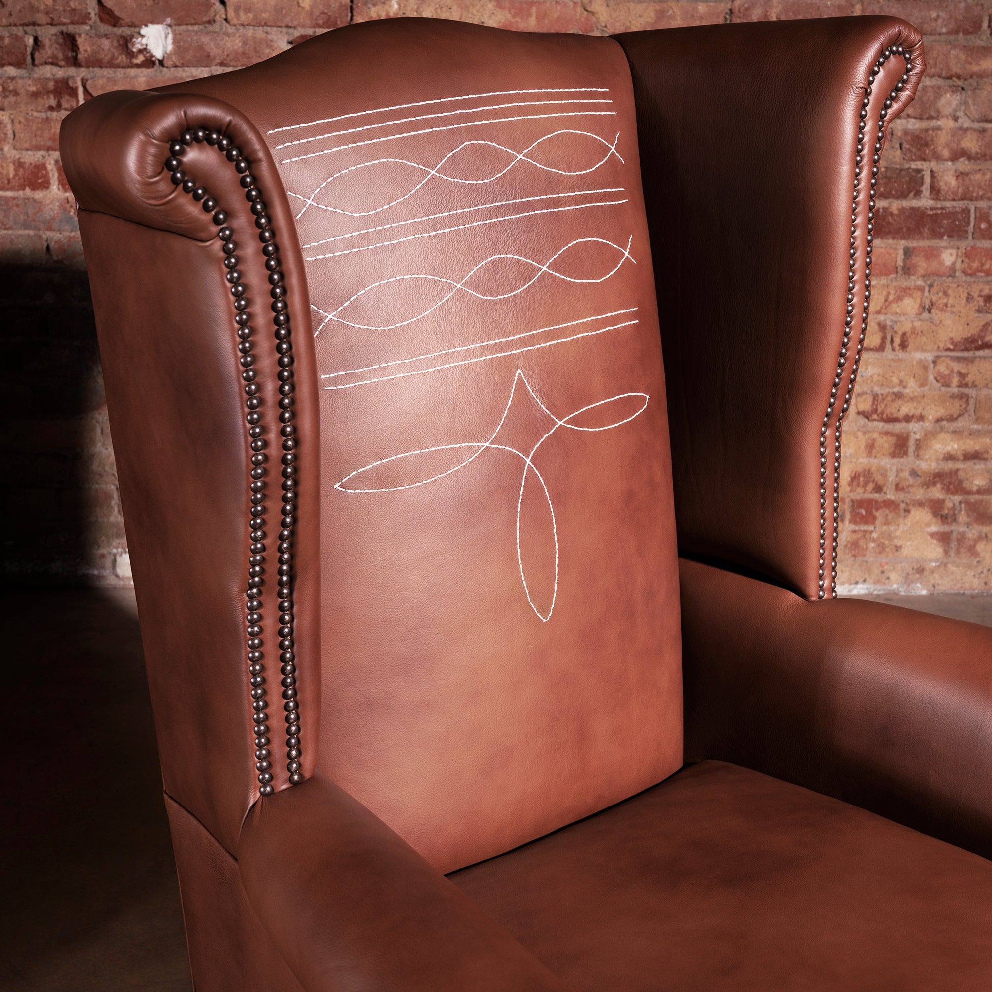 Side view of Western wingback chair with rolled arms and top-grain leather