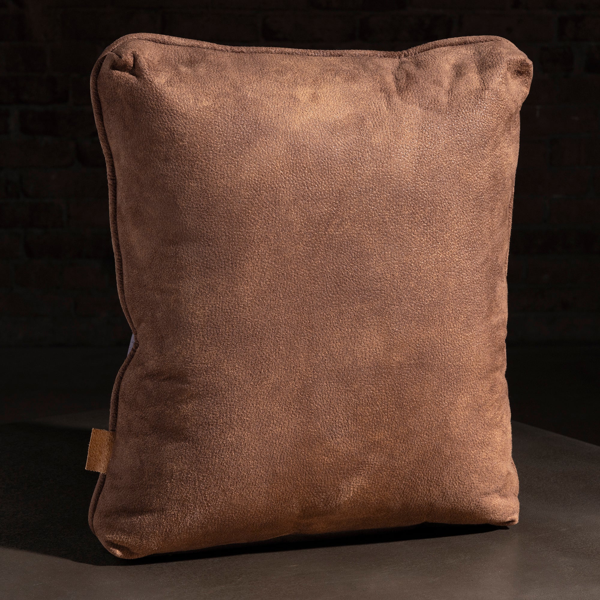 western throw pillow with soft suede back, tailored piping, and warm saddle-brown tone