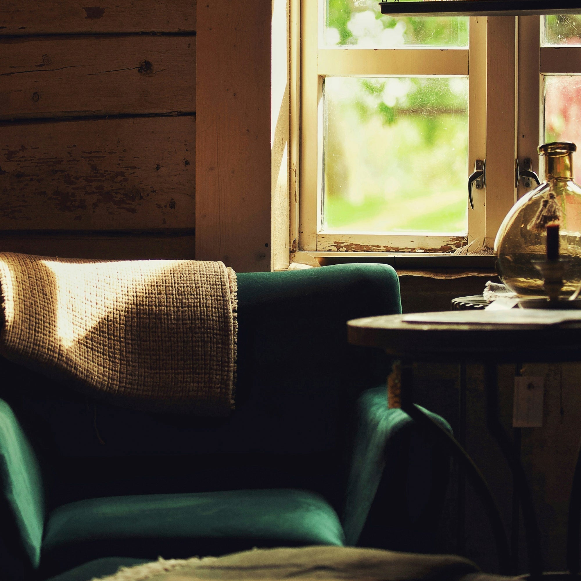 A worn chair facing a ranch window, lit by soft morning light