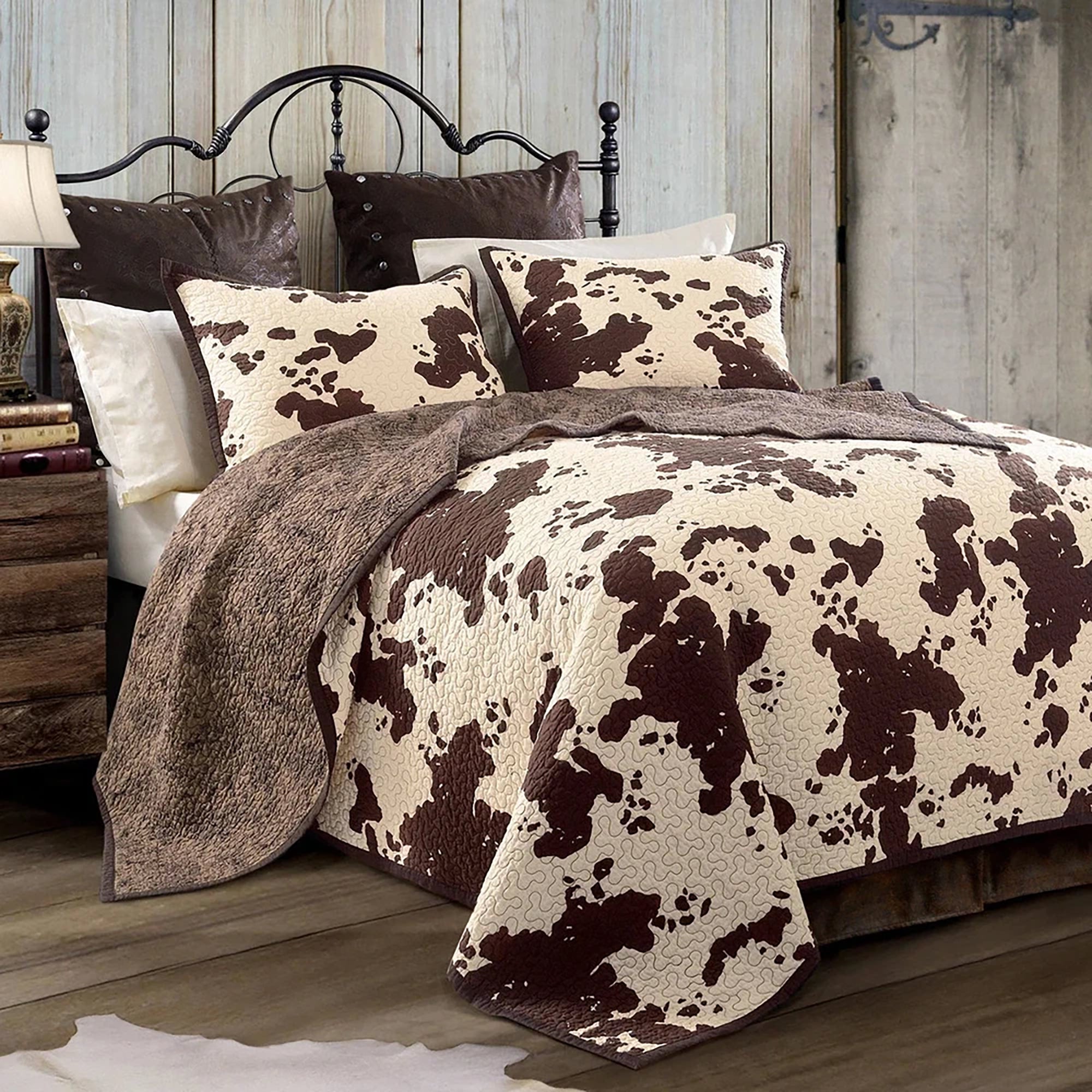 Western guest bedroom with iron bed, hide, nightstand, and warm lighting styled for comfort