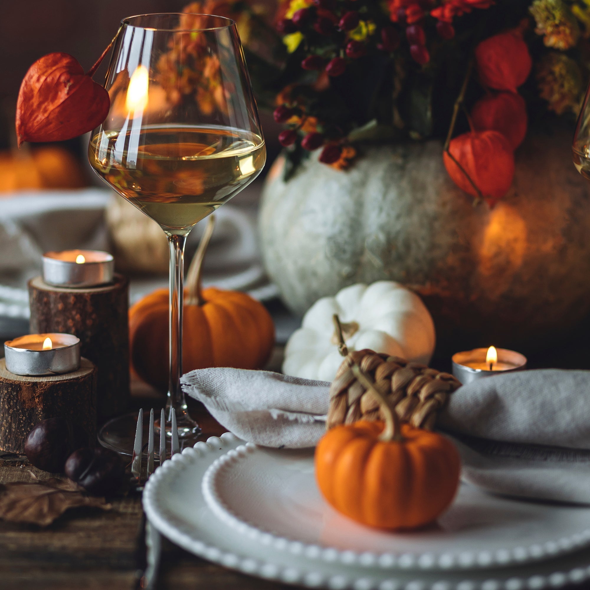 Western Thanksgiving dining table with copper chargers, leather chairs, hide runner, and candlelit centerpiece