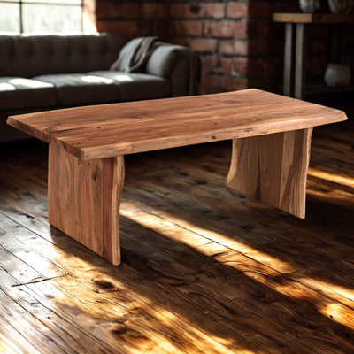 Live-edge acacia wood coffee table with slab legs, warm natural grain, ranch living room style