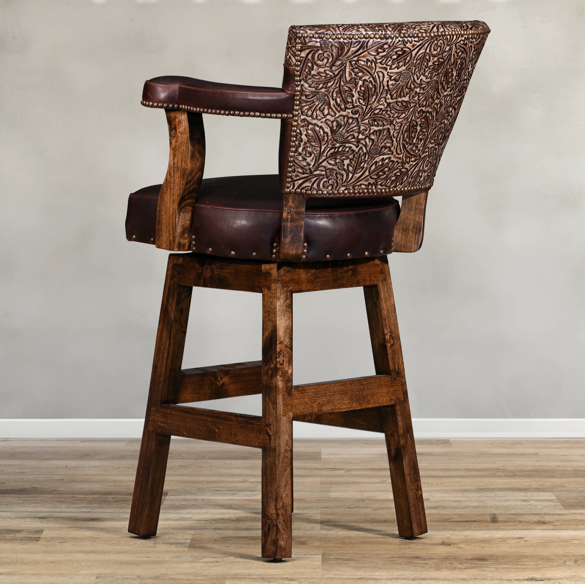 Experience rustic elegance with the Autumn Yoke Chisum Barstool. Its autumn tooled leather yoke and 100% top grain leather add a touch of sophistication, while the swivel feature offers convenience. Perfect for any bar or kitchen, this barstool combines style and function seamlessly.