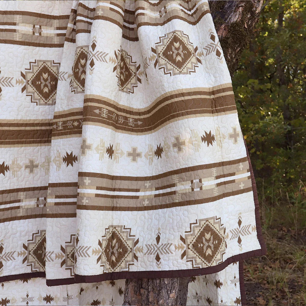 Discover classic Southwestern style with our Dakota Quilt Set, featuring Native American-inspired designs and a neutral earth-tone color palette. Relax with horizontal stripes, arrow motifs, and diamond patterns in shades of taupe, brown, and tan. Create a calming and tranquil bedroom atmosphere.