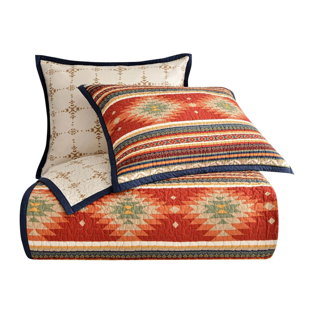 Transform your bedroom into a tranquil oasis with the Del Sol Quilt Set. This sophisticated modern twist on traditional Southwestern design features vibrant desert hues and superb Aztec-inspired patterns, framed by a navy flanged border for a bold, modern touch. Easily switch between two sides for added depth and a soothing, earthy look.