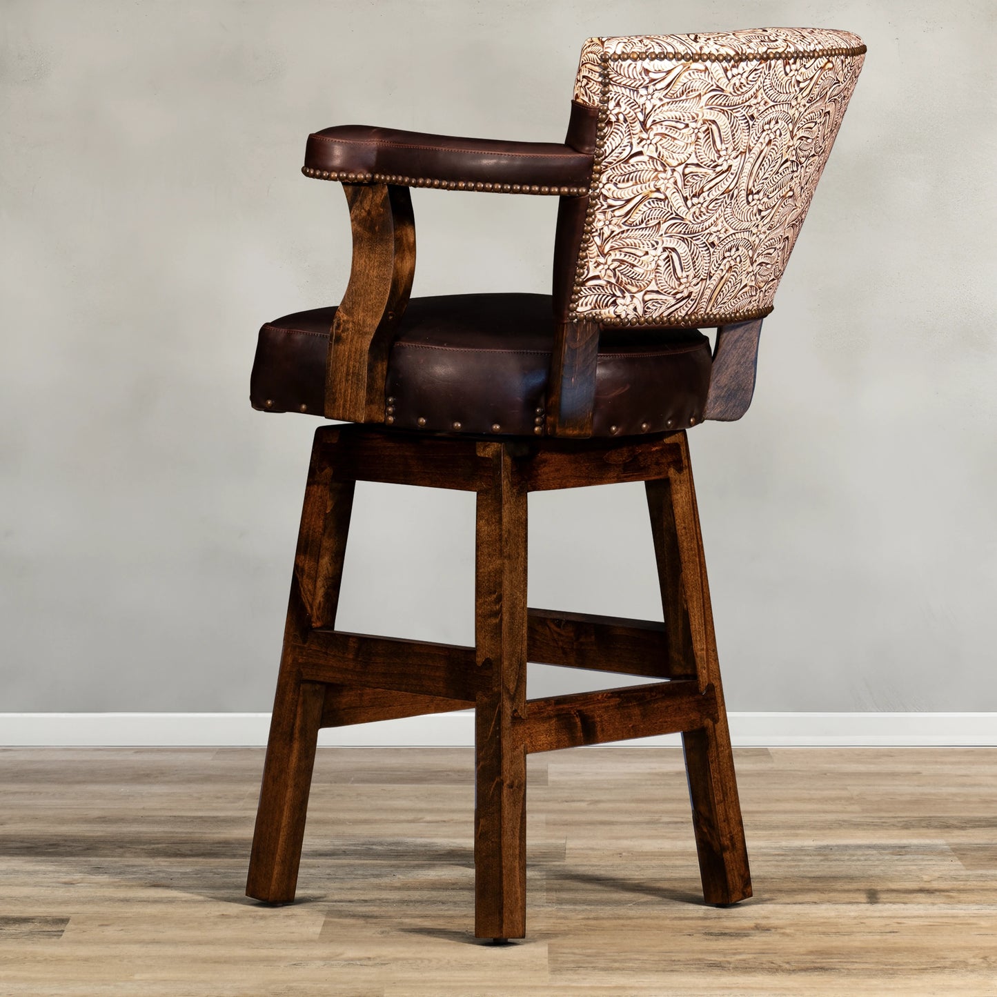 Experience ultimate comfort and style with our Floral Yoke Chisum Barstool. Made with high-quality leather and accented with nail detailing, this stool also boasts an embossed leather yoke and swivel feature. Perfect for any space, it offers both durability and luxury.