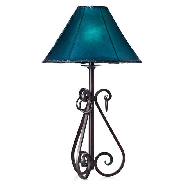 This rustic table lamp is a hand forged work of art. Constructed with durable and strong iron, the lamp combines strength and beauty for a unique and stylish lighting accessory. Perfect for any room or setting, this lamp provides a rustic atmosphere to any home.