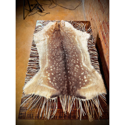 Enhance the aesthetic of your coffee table or dining table with our premium Fallow Deer Hide Table Topper. Made from luxurious fallow deer hide, this topper features a stunning leather fringe detail for added elegance. Perfect for adding a touch of sophistication to any table setting.  Ships within one week.
