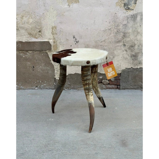 The Horn Tripod Side Table is the perfect blend of classic and modern style. Crafted with a cowhide top and beautiful horn leg base, this end table adds a stylish accent to any room. Durable and timeless, this piece looks great in any home.