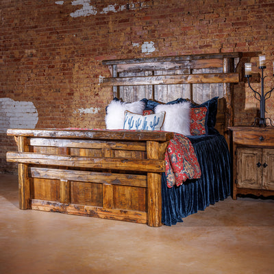 Classic rustic western bed frame with arched wood headboard and footboard in a cozy ranch bedroom