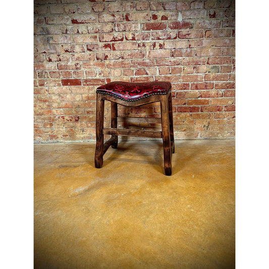 Elevate your seating experience with our Red Leather Brand Saddle Stool. Crafted from high quality red leather and accented with a branded embossing, this saddle stool adds a touch of sophistication to any space. The solid wood base and nailhead trim provide both durability and style. Bring luxury to your home or office with this statement piece.