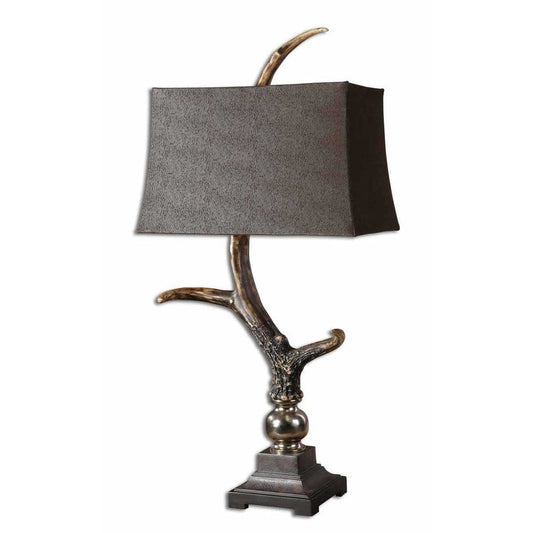 Elevate your home decor with the Stag Horn Table Lamp. Crafted with a burnished bone ivory finish, wood tone base and cast aluminum accents, this lamp is a beautiful addition to any room. The rectangle semi drum shade has a luxurious sueded chocolate fabric for a touch of sophistication.
