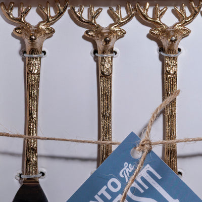 Close-up of gold-tone deer head handles on Western-style appetizer forks